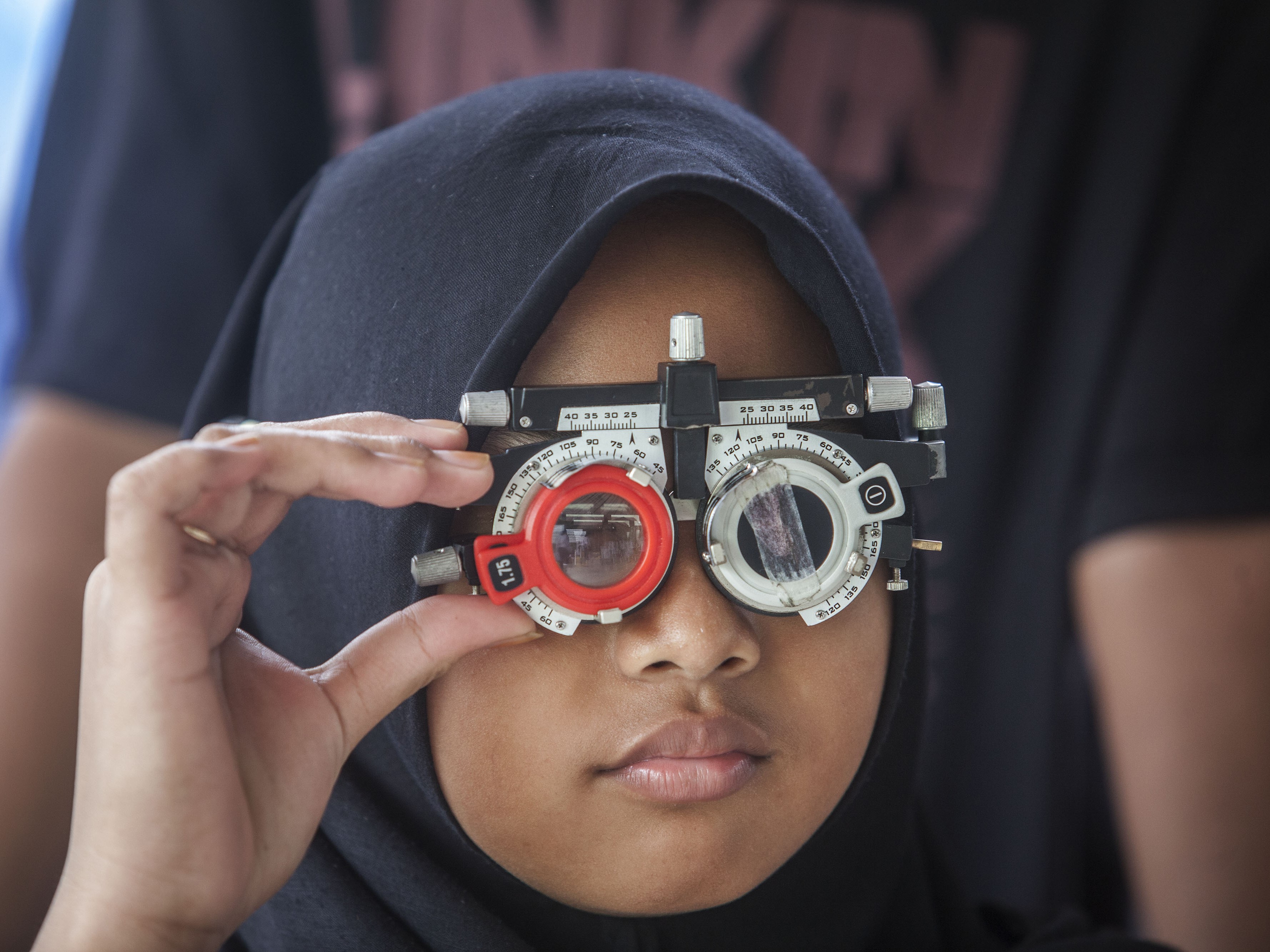 Seorang anak menjalani pengukuran lensa kacamata saat bakti sosial.