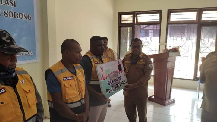 Penjabat Bupati Sorong, Papua Barat, Yan Piet Moso menyerahkan bantuan sosial kepada pengemudi ojek