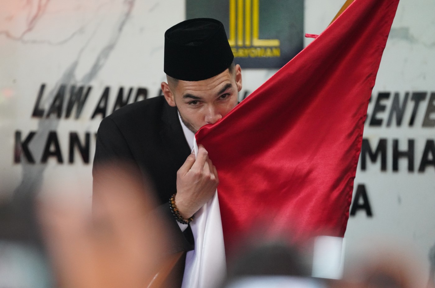 Pesepak bola Jordi Amat mencium bendera Merah Putih seusai mengucapkan Sumpah dan Janji Setia sebagai WNI di Kanwil Kemenkum HAM DKI Jakarta