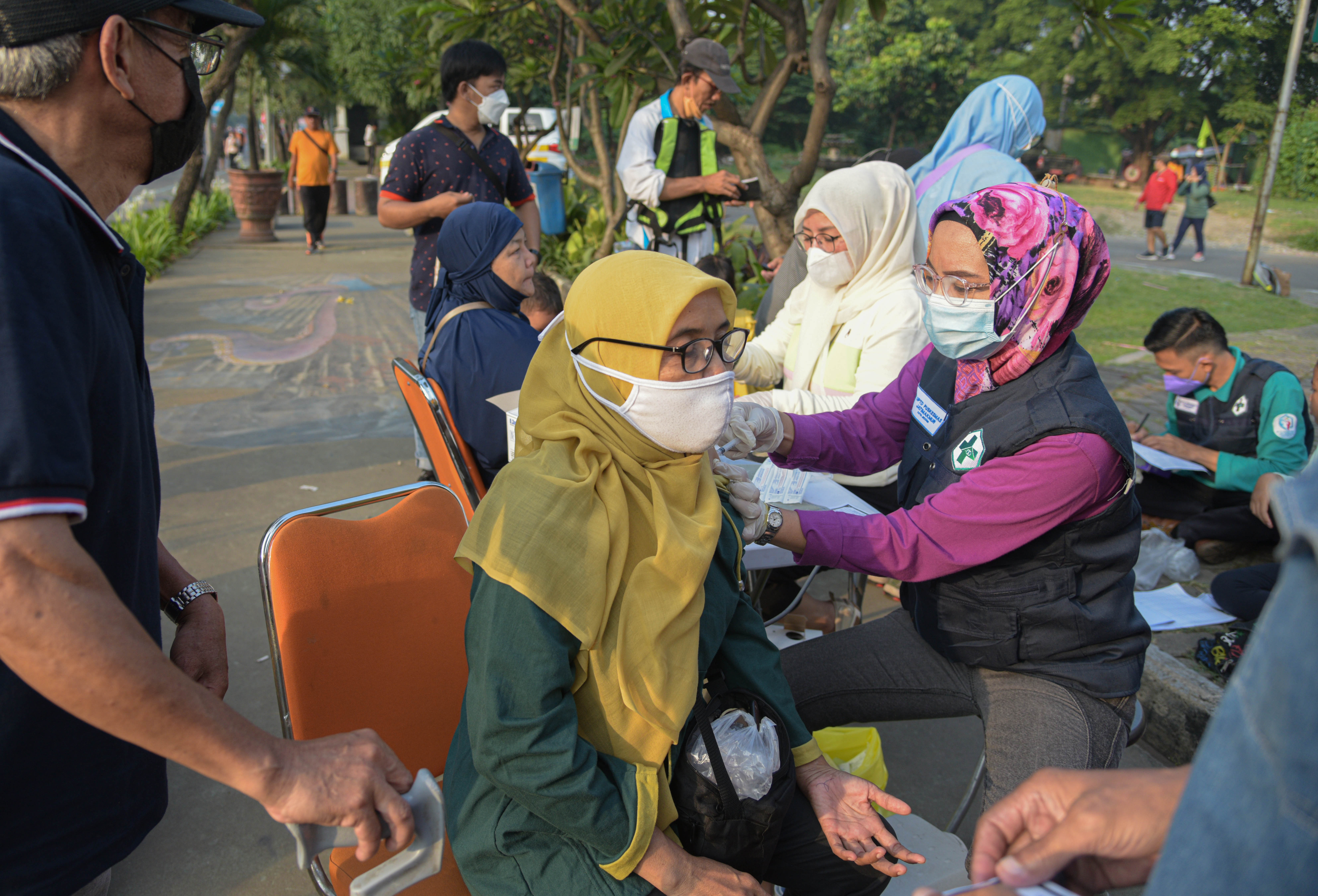 Seorang petugas kesehatan menyuntikkan vaksin covid-19 kepada warga di Jalan A Yani, Bekasi, Jawa Barat, Minggu (24/7).