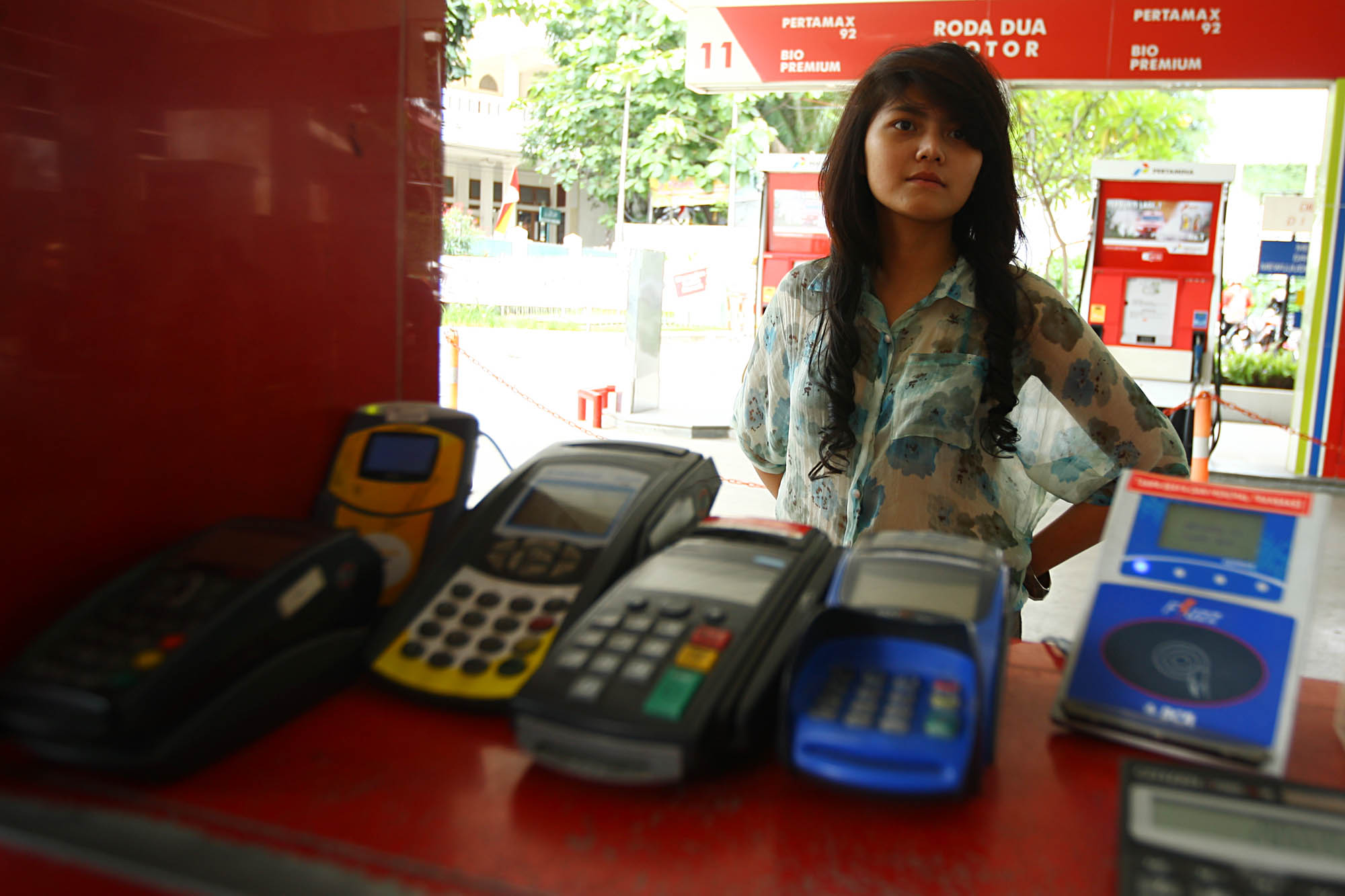 Seorang perempuan bertransaksi menggunakan mesin EDC di sebuah SPBU di kawasan Kuningan, Jakarta.
