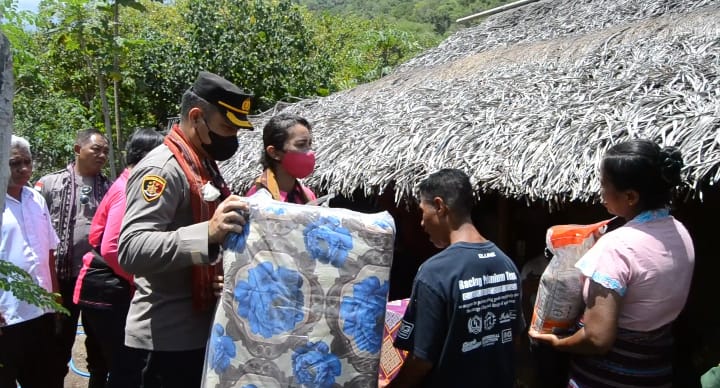 Kapolres Flotim AKBP I Gede Ngurah Joni Mahardika bersama istrinya Dhana memberikan bantuan kepada warga tidak mampu.
