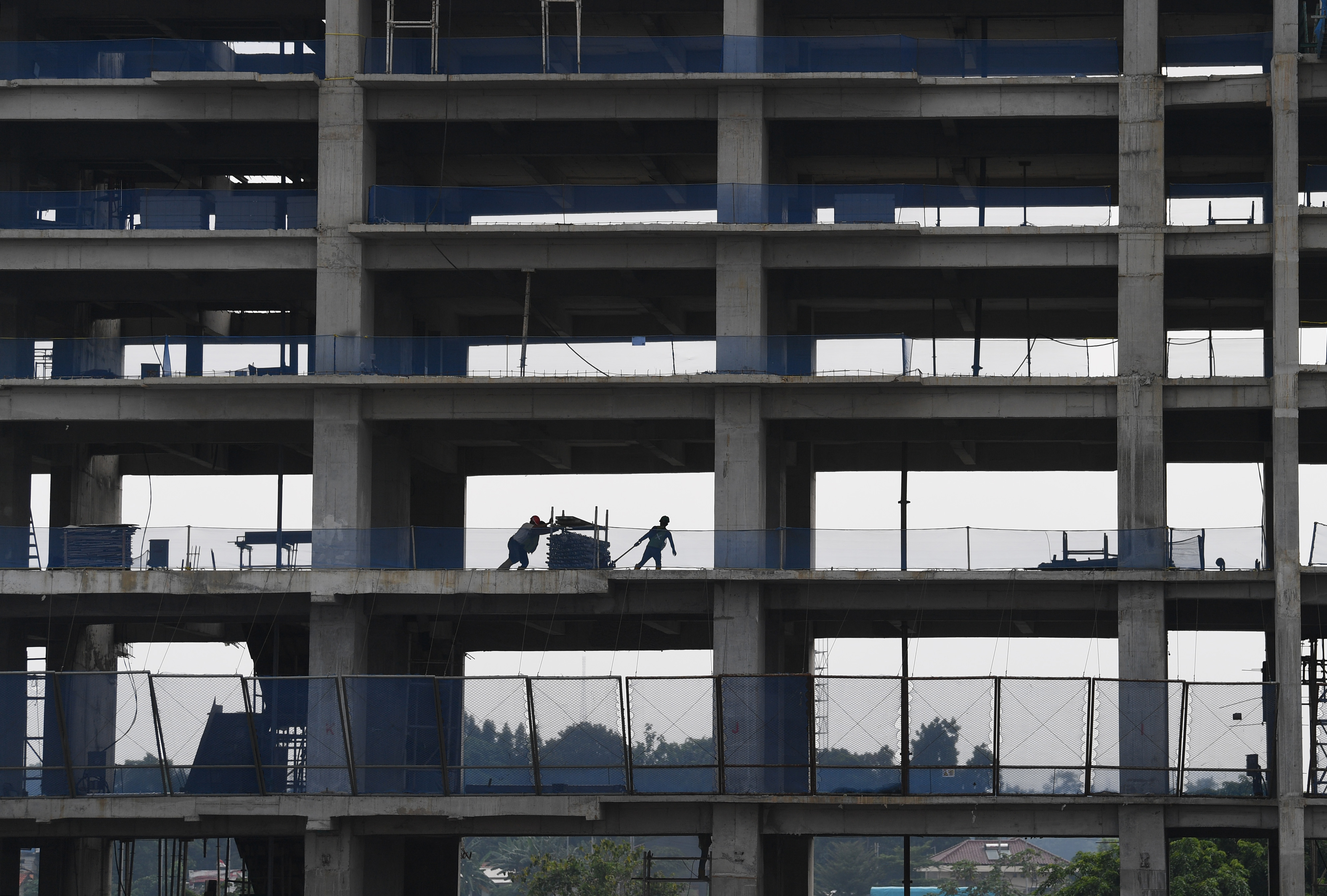 Sejumlah pekerja menyelesaikan pembangunan gedung bertingkat di Jakarta.