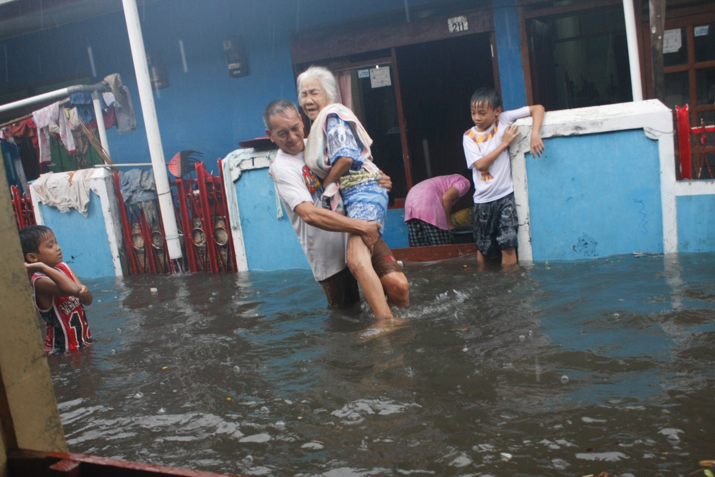Seorang kakek saat mengevakuasi nenek dan anak-anak dari genangan banjir di Jalan Johar 1, Sukmajaya, Depok, Jawa Barat, Jumat lalu.
