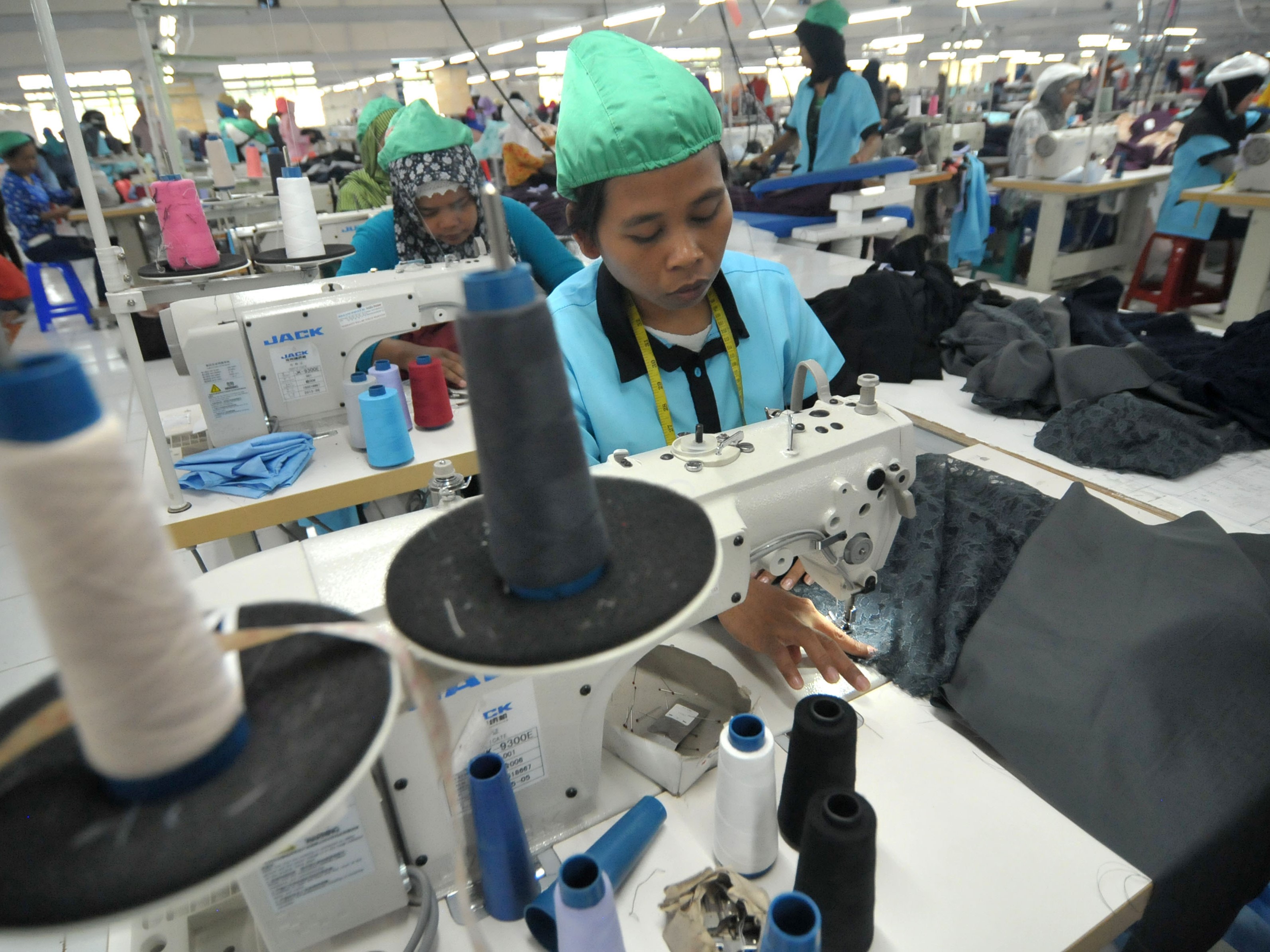 Pekerja menyelesaikan proses menjahit kain di salah satu industri garmen, Tegal, Jawa Tengah.