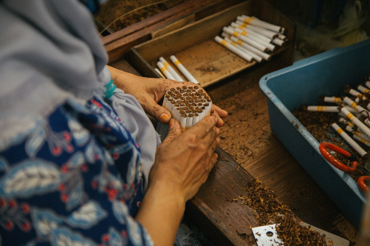Pekerja menyelesaikan pembuatan rokok yang termasuk barang kena cukai