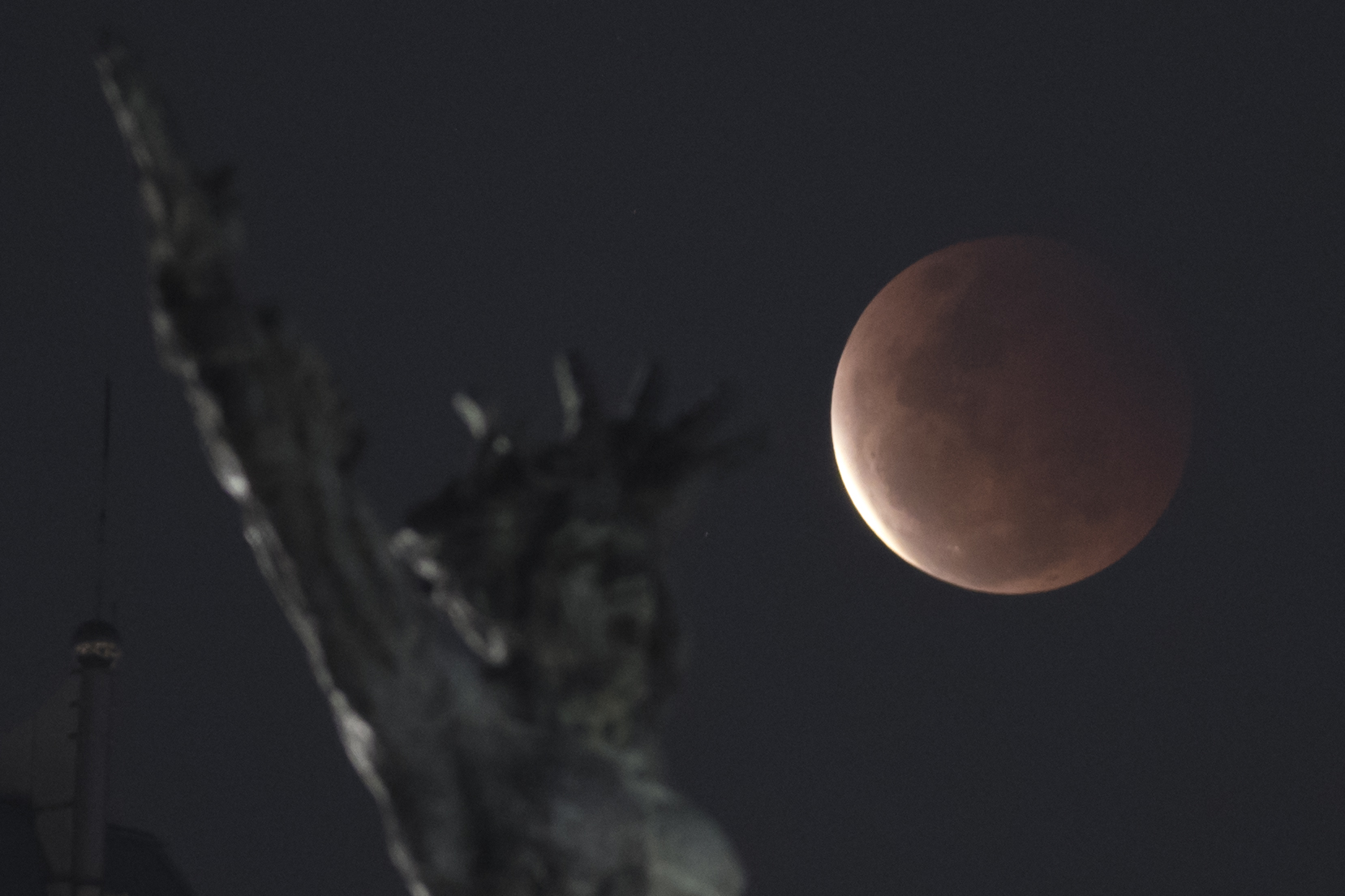  Fase gerhana bulan total terlihat dengan latar depan tugu pembebasan Irian Barat di Lapangan Banteng,