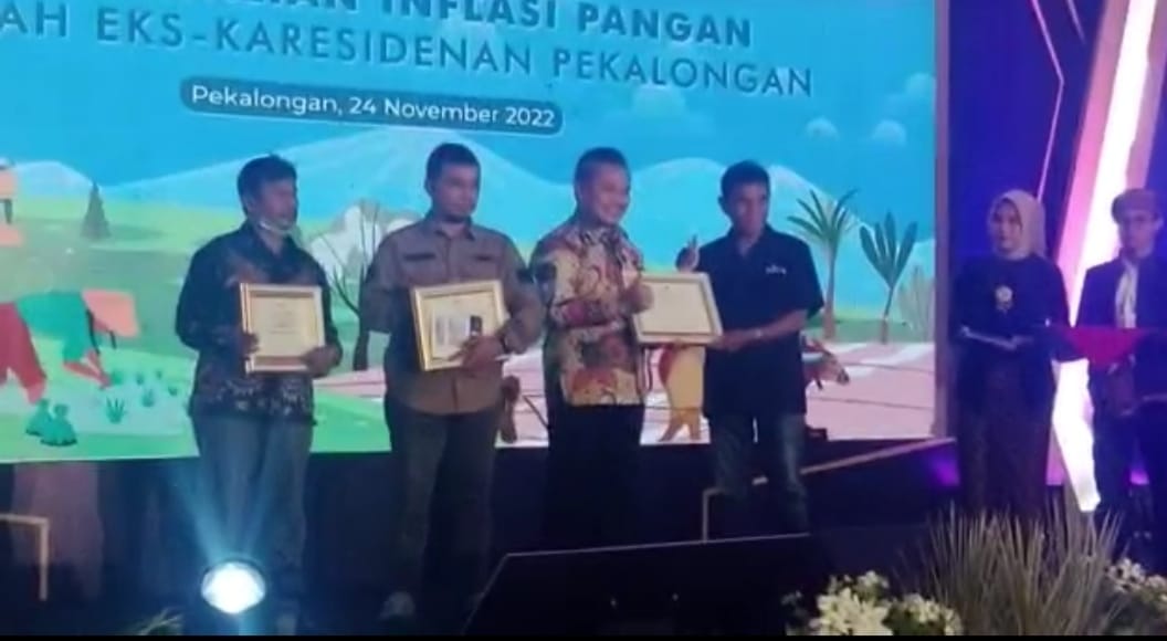 Kepala BI Tegal, M. Taufik Amrozi (baju batik) menyerahkan penghargaan Media Terbaik kepada koresponden MI, Supardji Rasban (baju hitam).