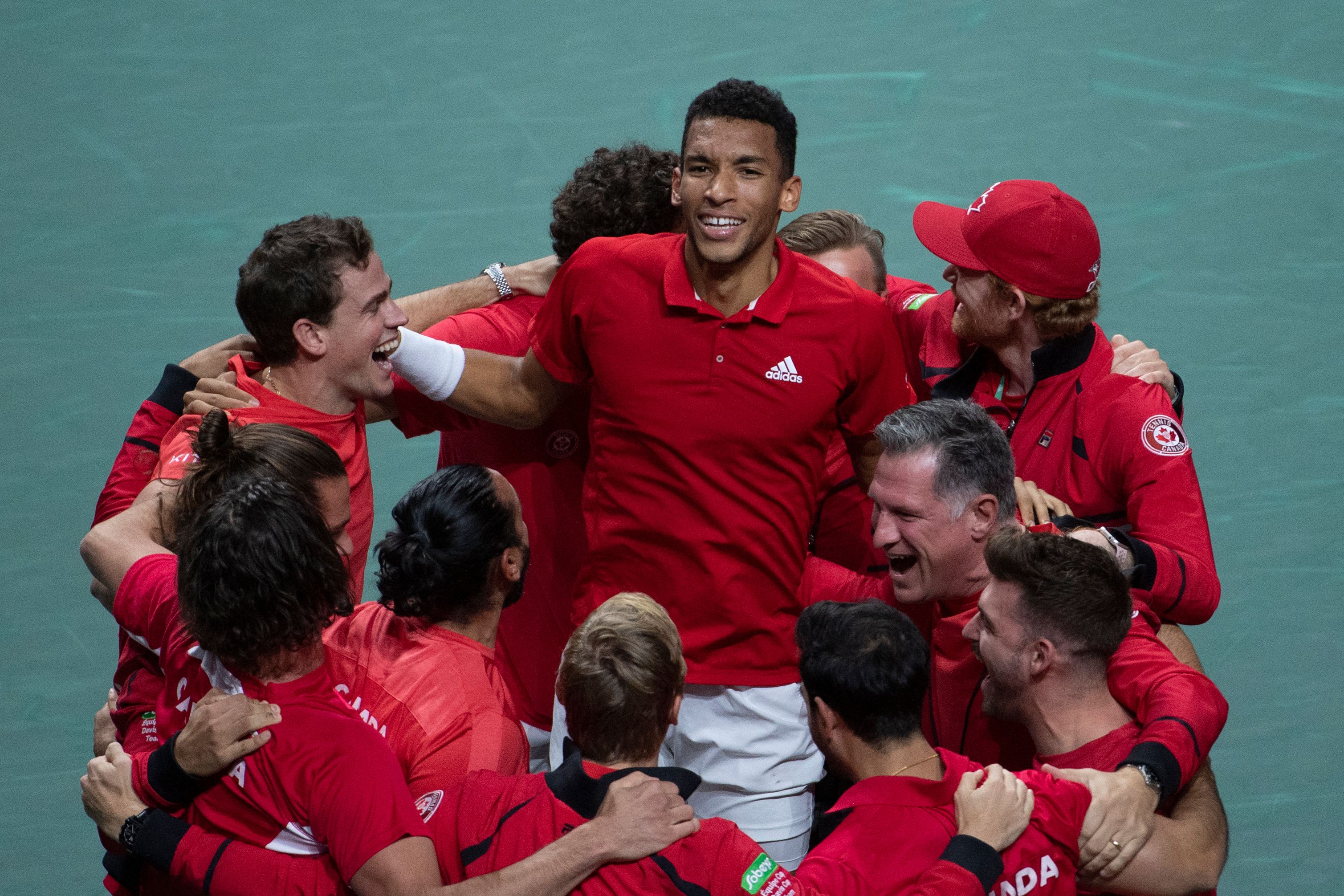 Felix Auger-Aliassime (tengah) melakukan selebrasi bersama tim Kanada usai menjadi juara Piala Davis.