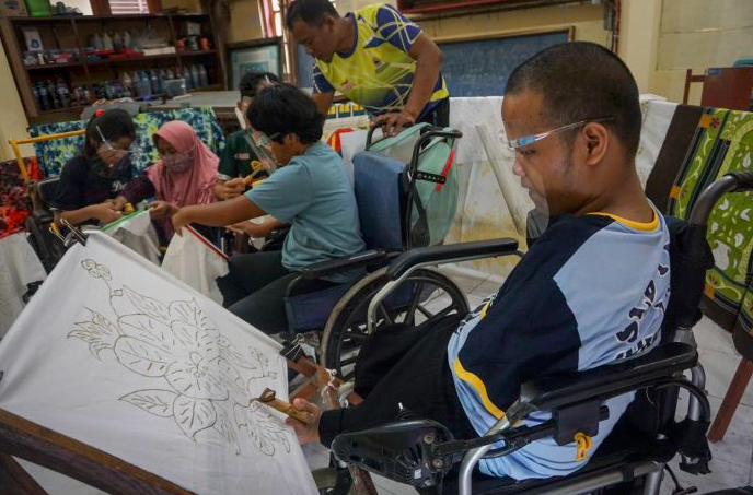 Guru membimbing siswa penyandang disabilitas belajar membatik di YPAC Solo, Jawa Tengah, Rabu (2/11).