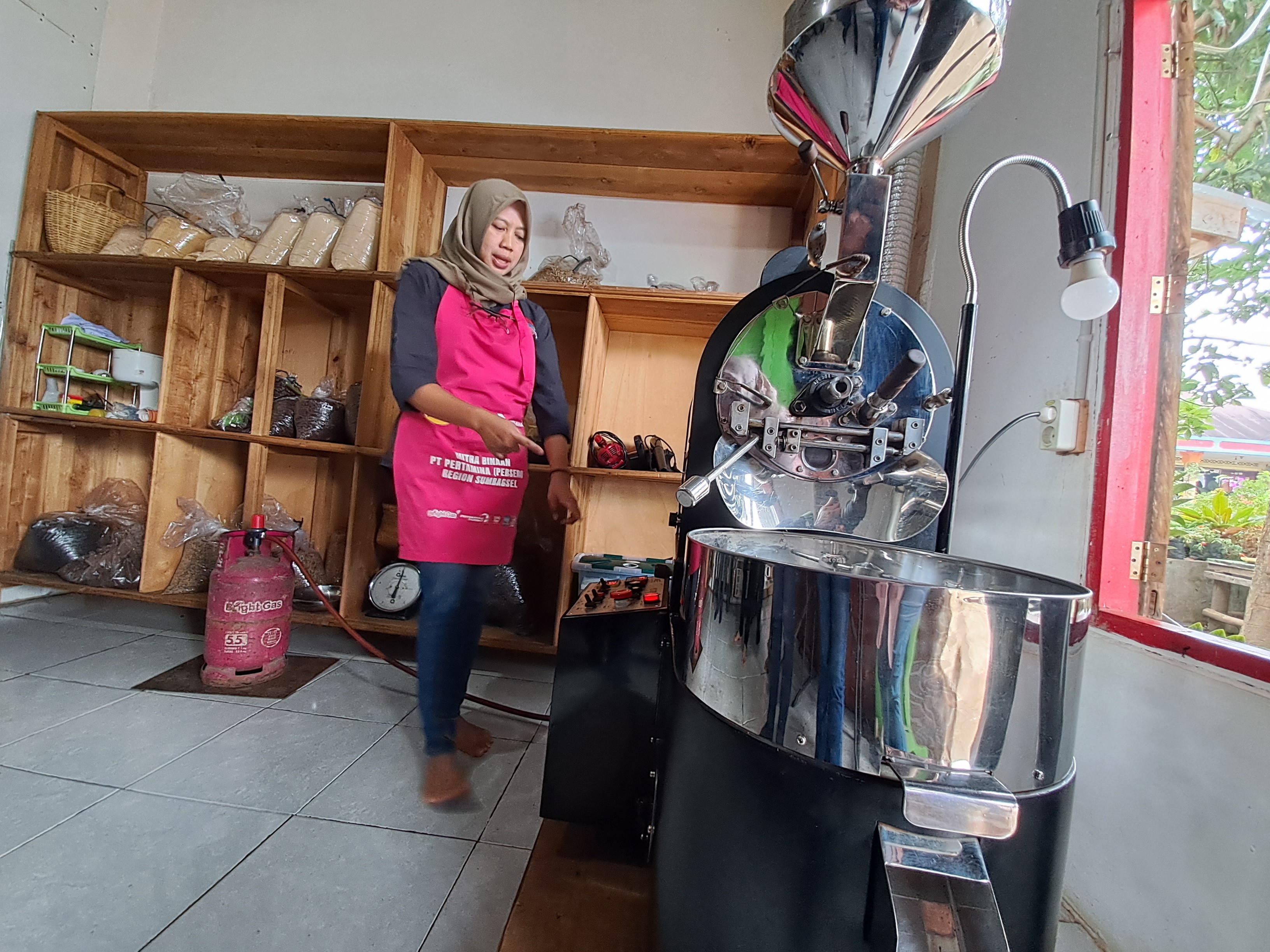 Weni Bastian, owner sekaligus pengelola kopi IKM Putra Abadi Pagaralam sedang sibuk menyangrai kopi robusta, Selasa (7/11/2022)