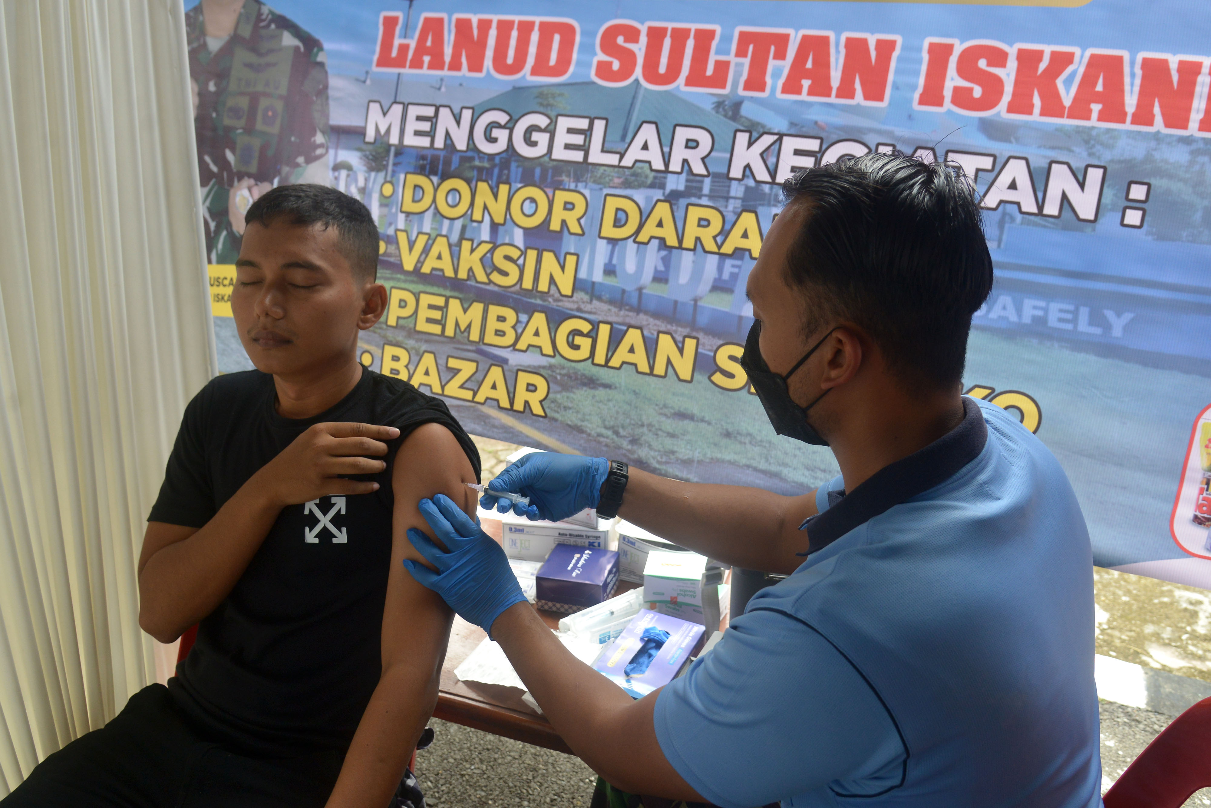 Petugas kesehatan TNI-AU menyuntikan vaksin COVID-19 kepada warga di Pangkalan Udara Sultan Iskandar Muda, Aceh, Jumat (14/10).