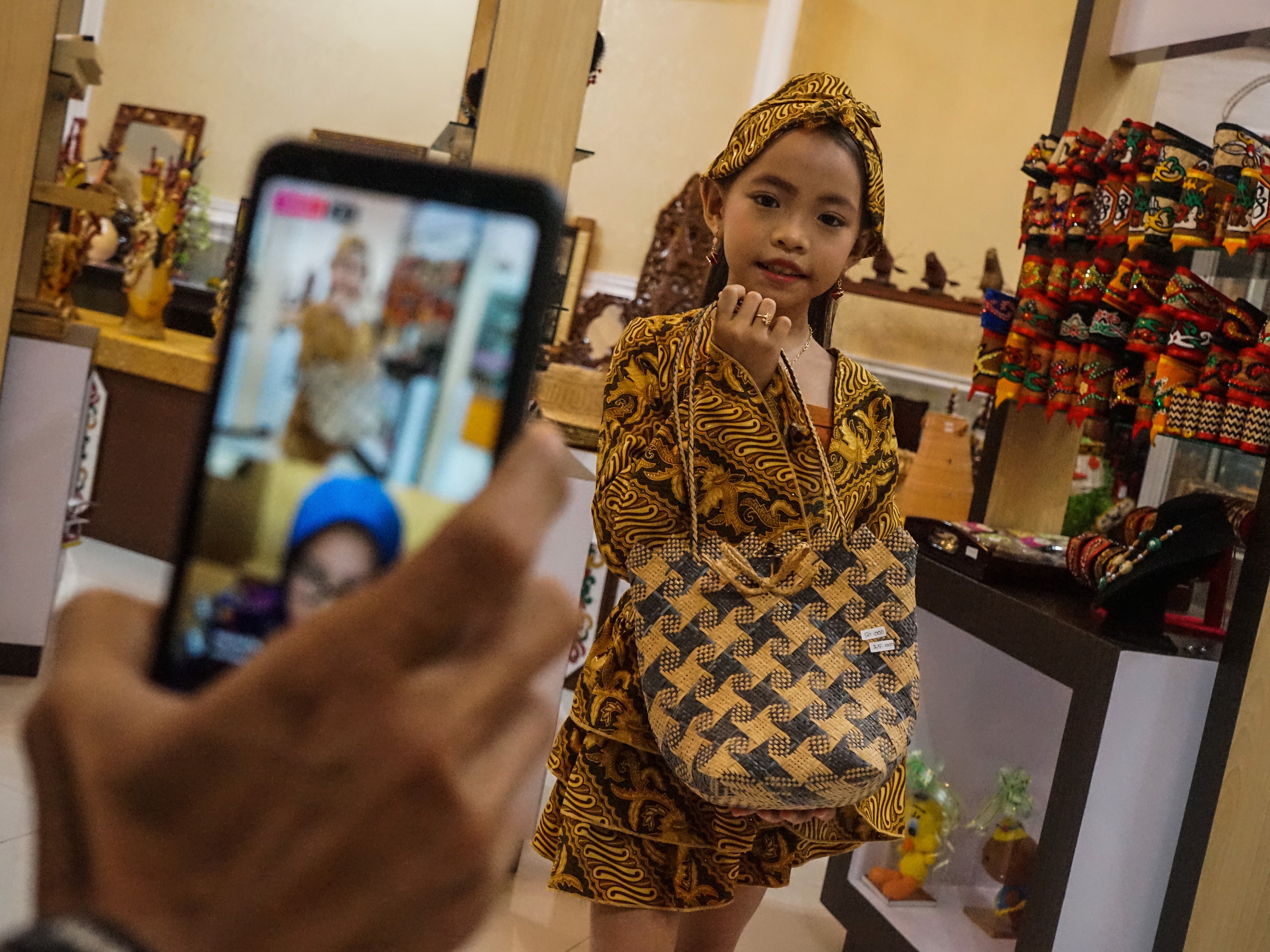 Model memperagakan produk kerajinan rotan yang disiarkan langsung secara daring (live streaming).