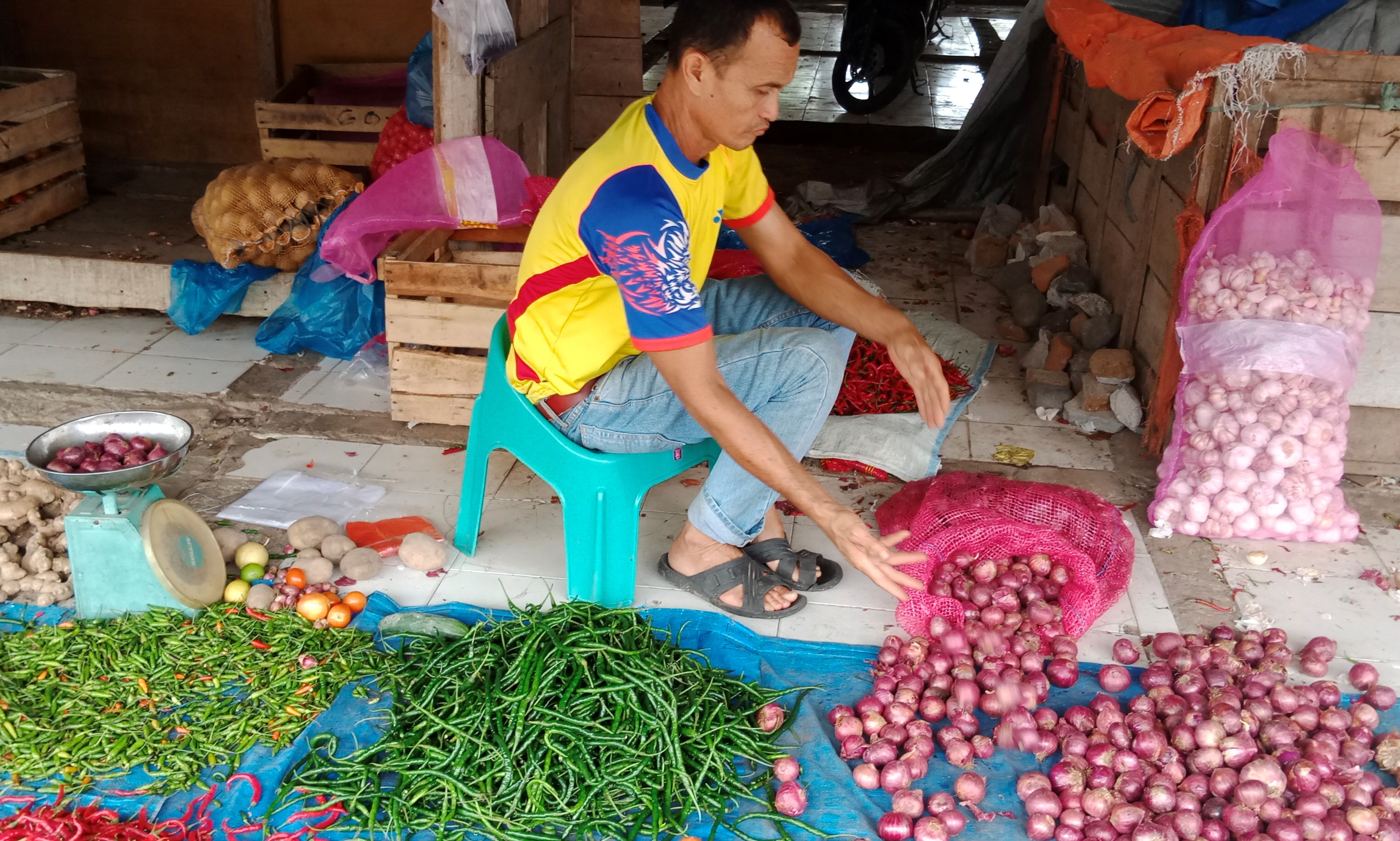 Pedagang bawang merah eceran dan bahan bumbu masakan lainnya, sedang beraktivitas di Pusat Pasar Sayur Pante Teungoh, Kota Sigli, Kabupaten