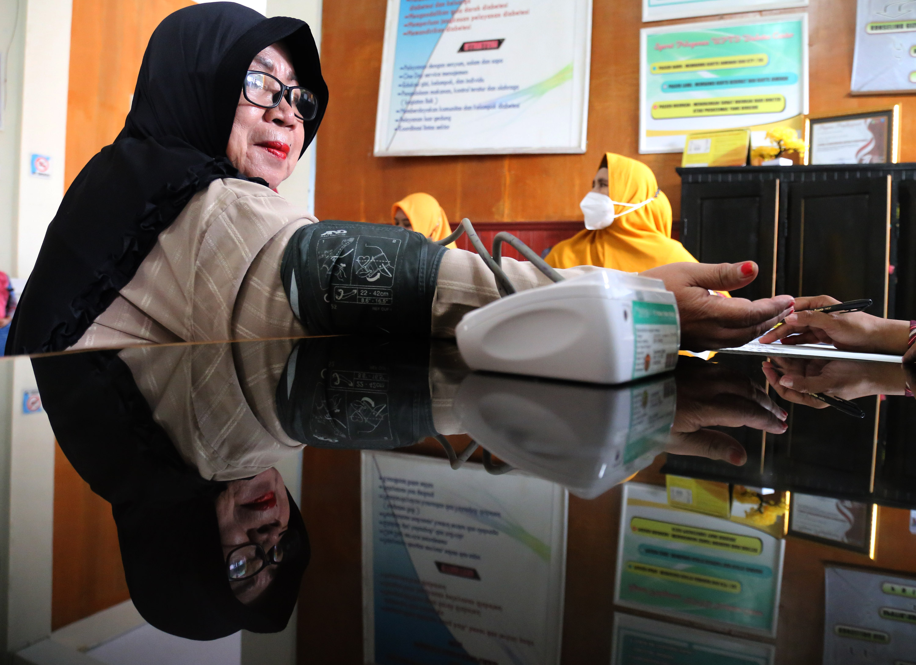 Petugas kesehatan memeriksa tekanan darah seorang warga saat memperingati Hari Diabetes Sedunia 