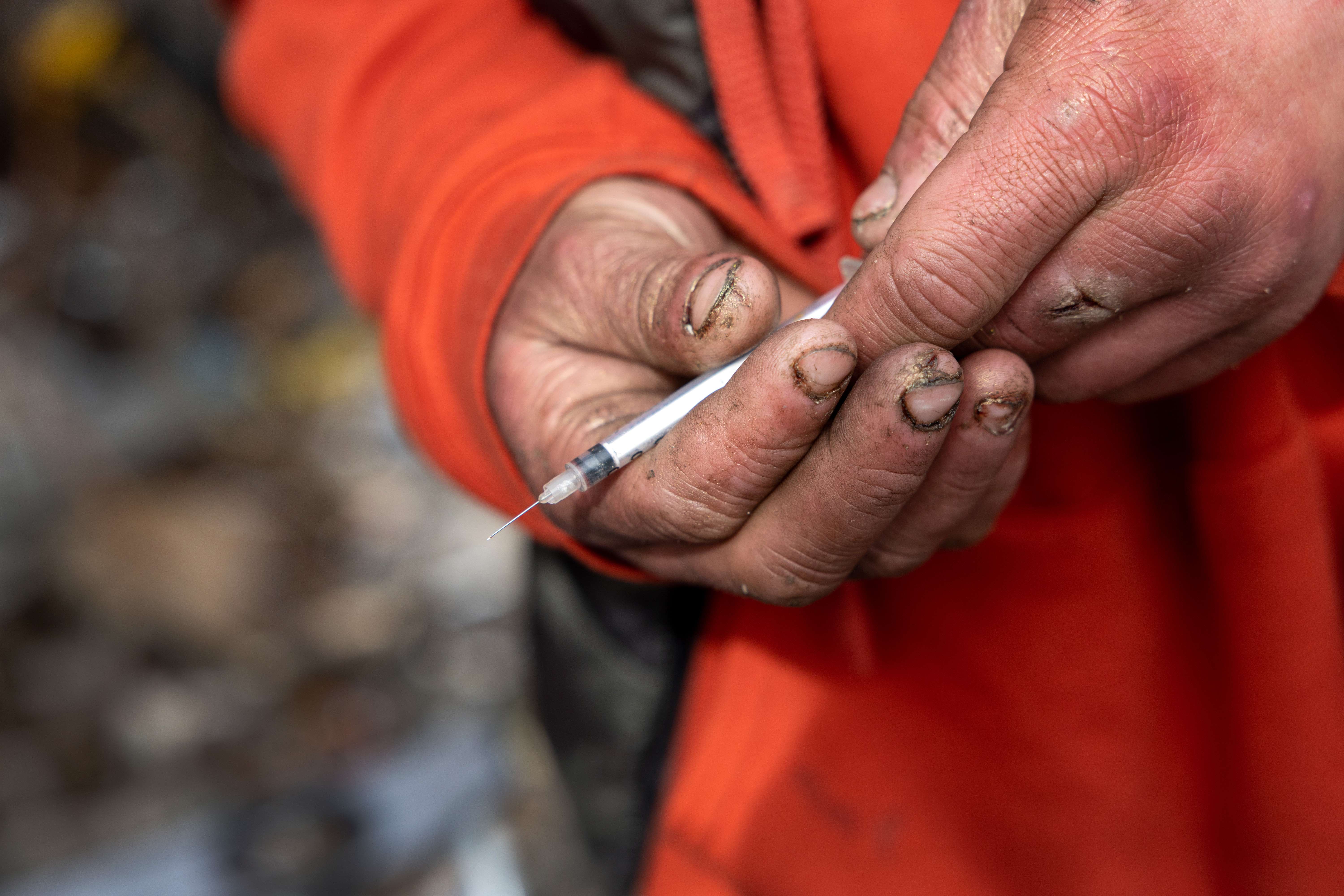 Seorang pemakai narkoba memegang alat suntik usai menginjeksi narkoba jenis sabu-sabu ke tubuhnya di Washington, Amerika Serikat.