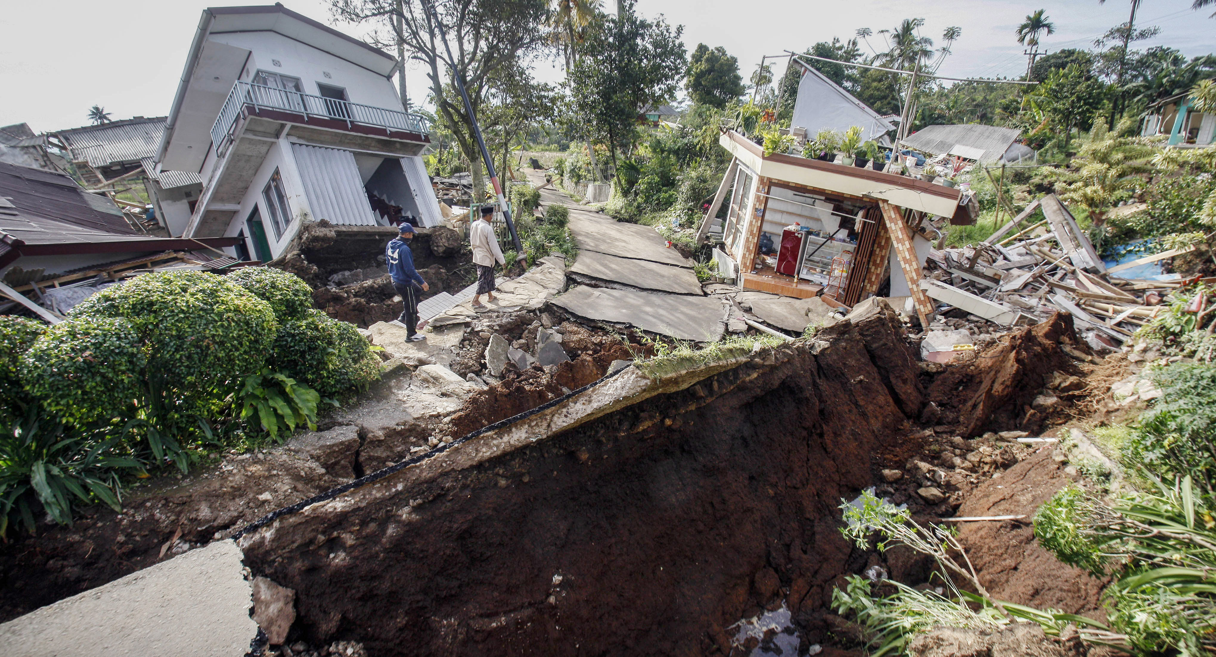  Warga melintas di dekat reruntuhan bangunan akibat gempa di Kabupaten Cianjur, Jawa Barat, Rabu (23/11/2022)