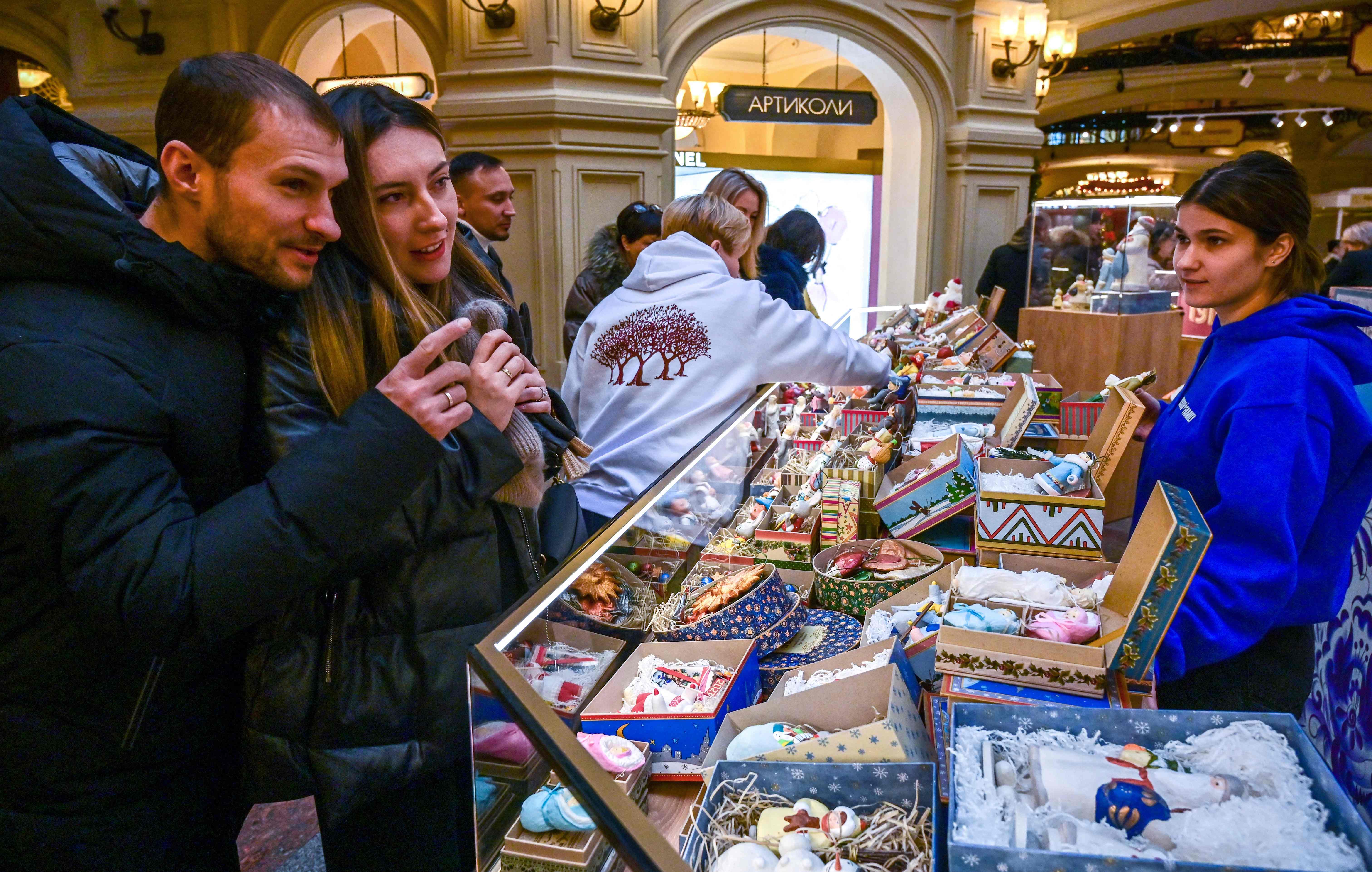 Warga berbelanja perlengkapan natal di Moskow, Rusia.