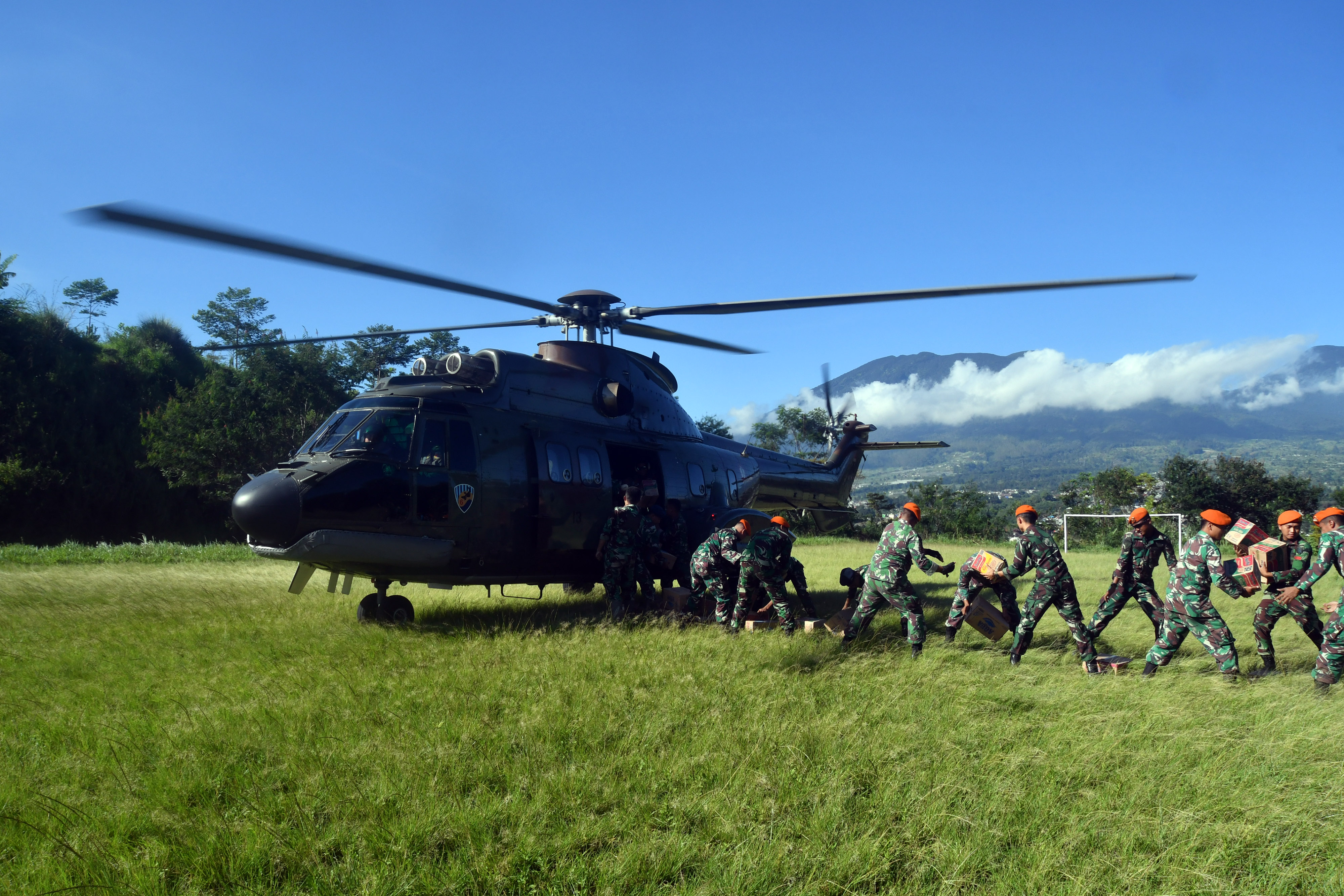 Sejumlah prajurit TNI AU menurunkan bantuan logistik untuk korban gempa bumi Cianjur dari helikopter.