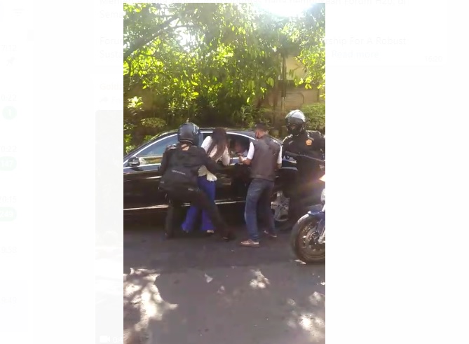 Tangkapan layar dari video yang menunjukkan pasukan pengamanan presiden berupaya mengamankan perempuan yang mendekati rombongan presiden.