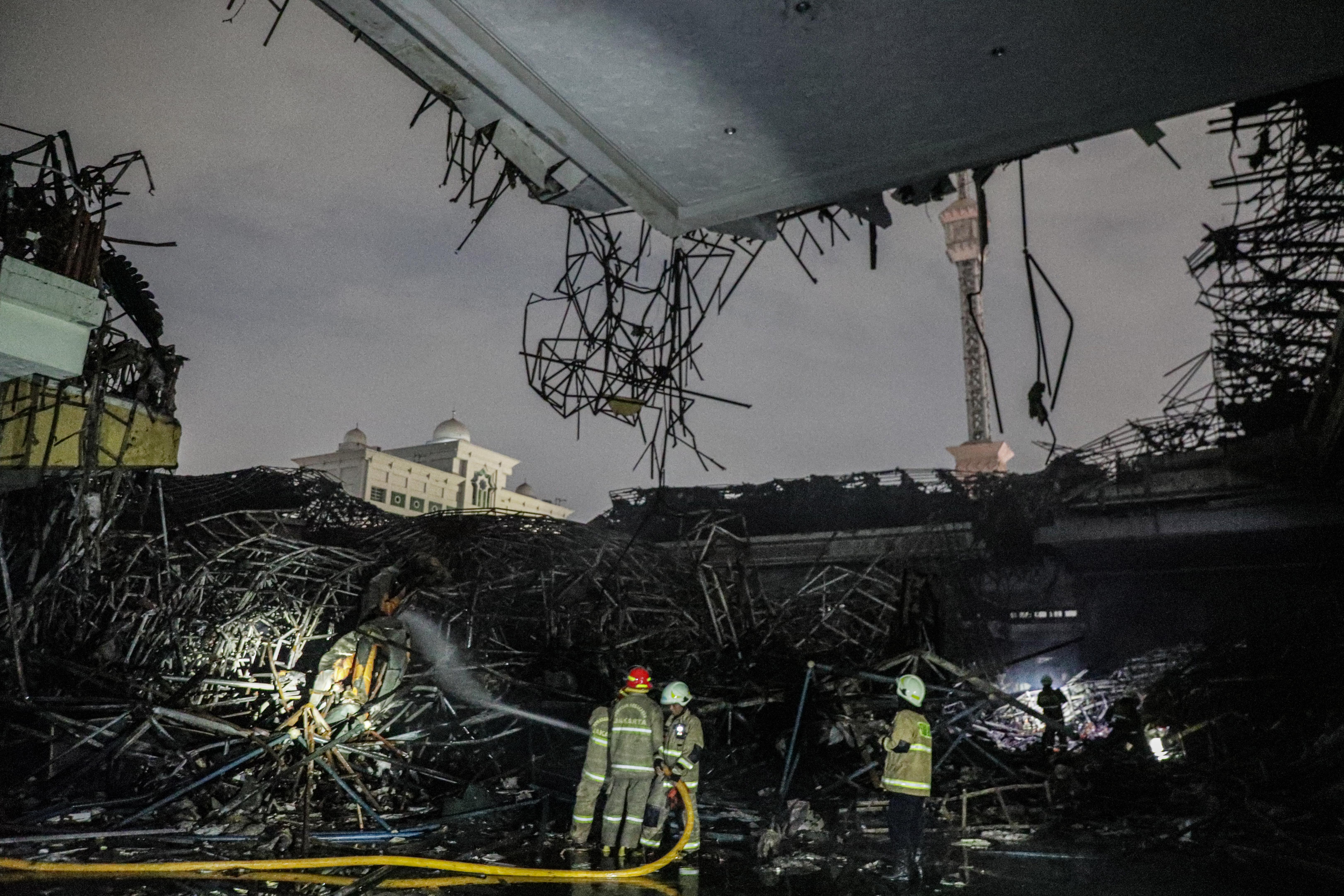 Petugas Dinas Penangggulangan Kebakaran dan Keselamatan (Gulkarmat) melakukan proses pendinginan reruntuhan kubah masjid JIC