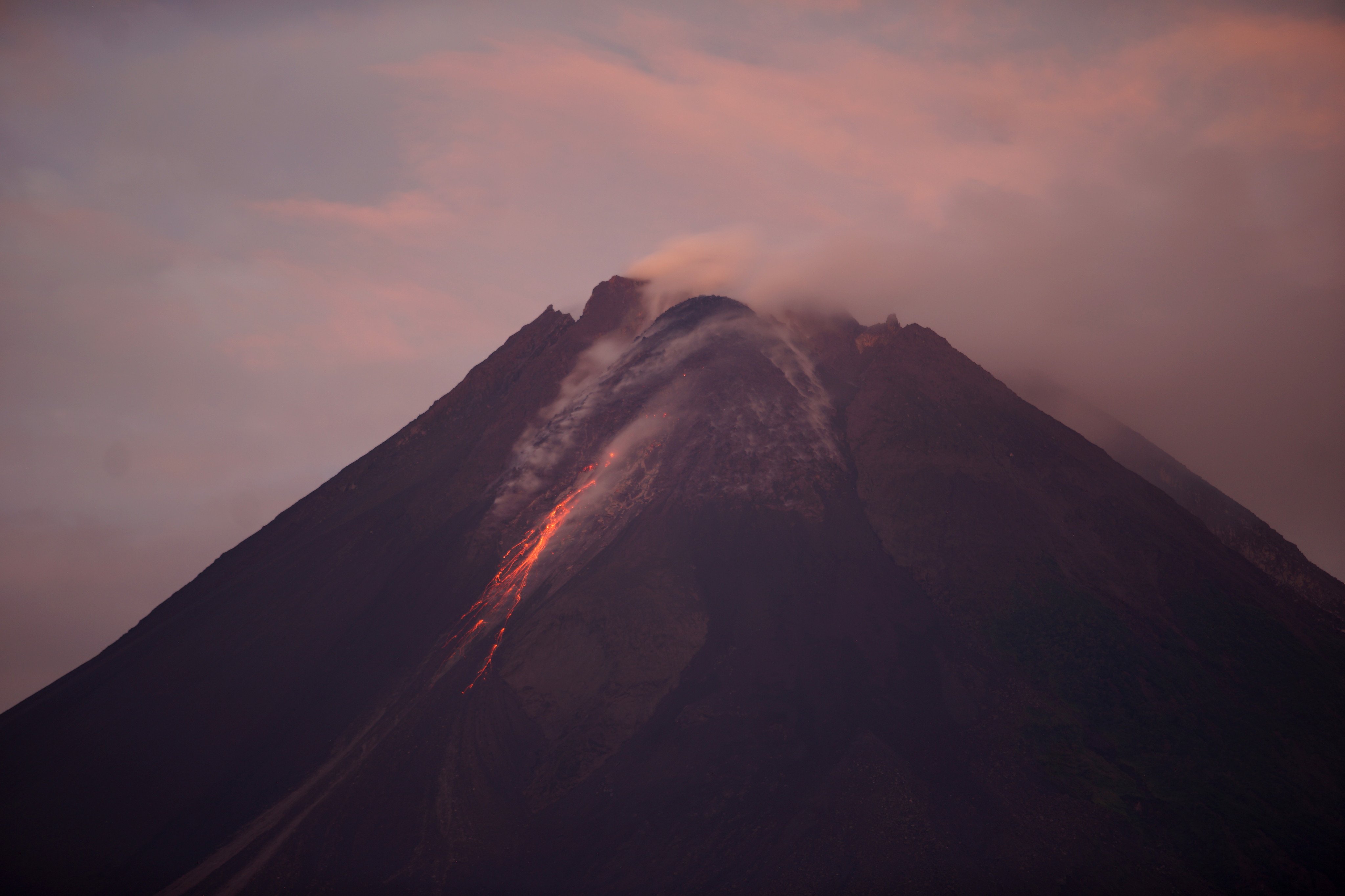 Gunung Merapi yang mengeluarkan lava pijar terlihat dari dari kawasan Turi, Sleman, Yogyakarta.