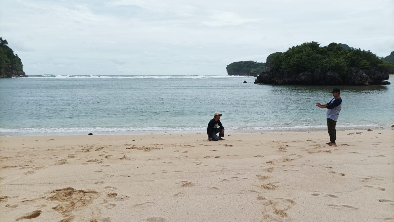 Dua pengunjung menikmati keindahan dan bersihnya Pantai Gatra di Kabupaten Malang, Jawa Timur. 