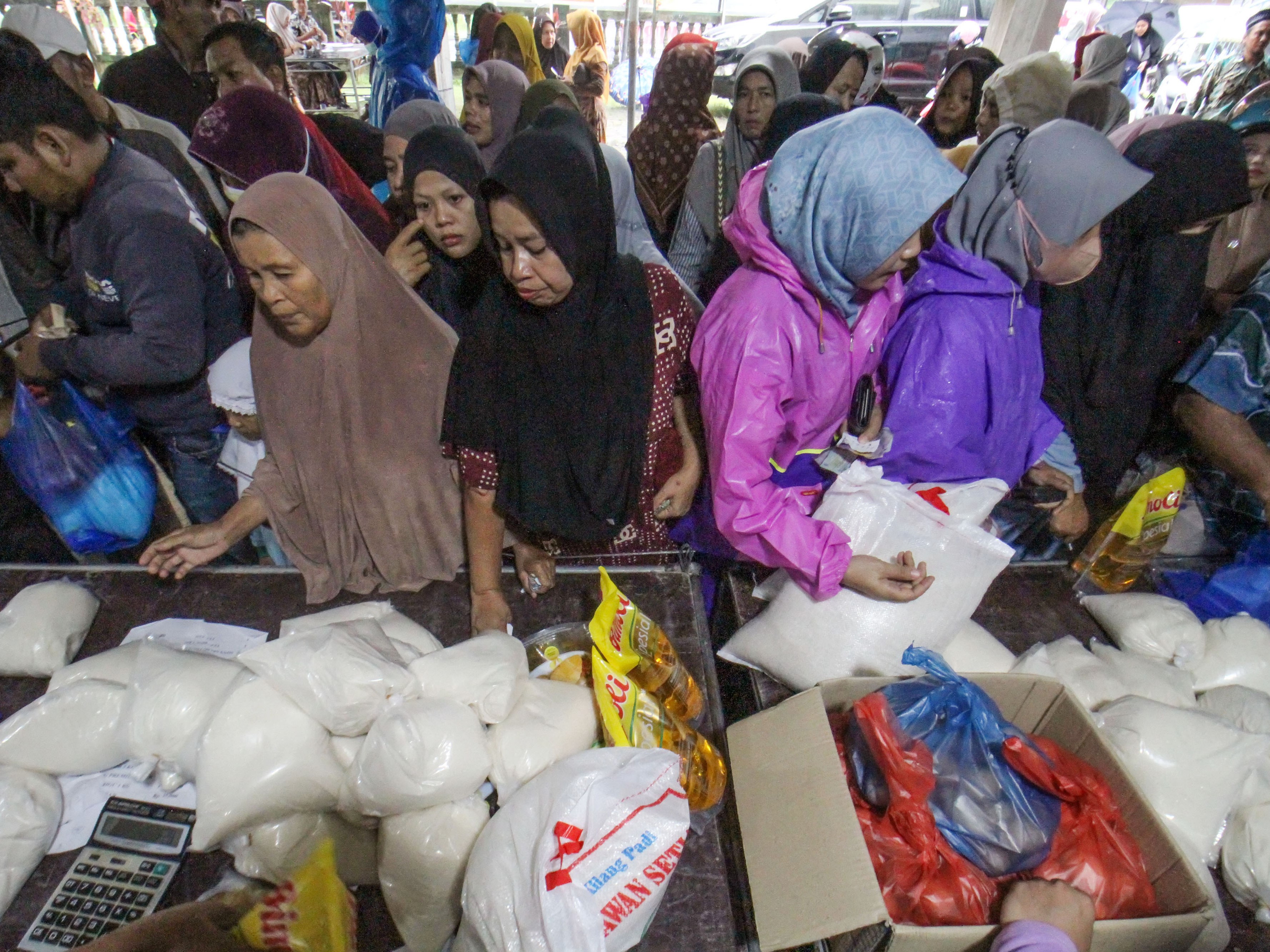 Warga antre membeli bahan pokok saat digelar pasar murah di Desa Ule Blang Mane, Kecamatan Blang Mangat, Lhokseumawe, Aceh.