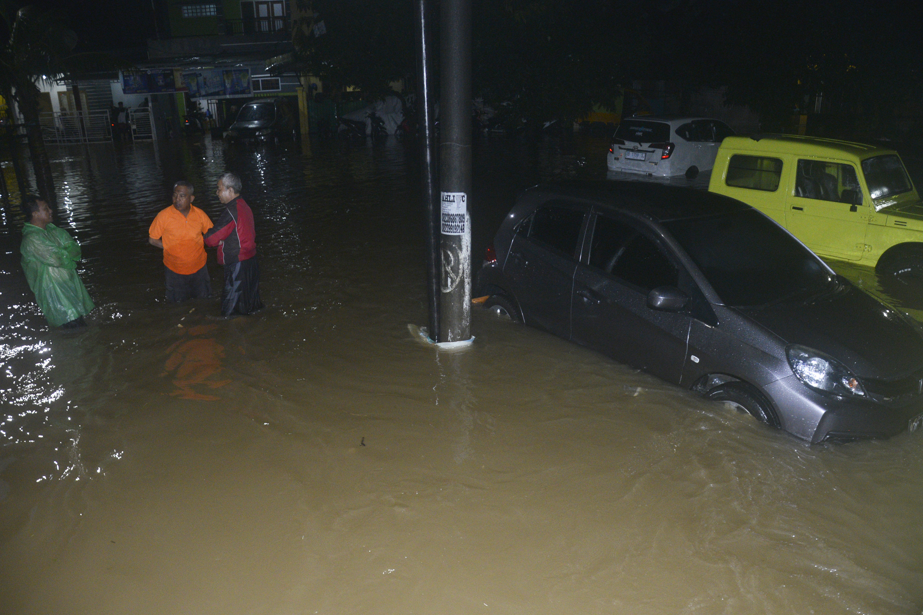 Tiga orang warga berbincang di tengah banjir yang melanda Perumnas Sudiang, Makassar, Sulawesi Selatan, Jumat (18/11/2022).