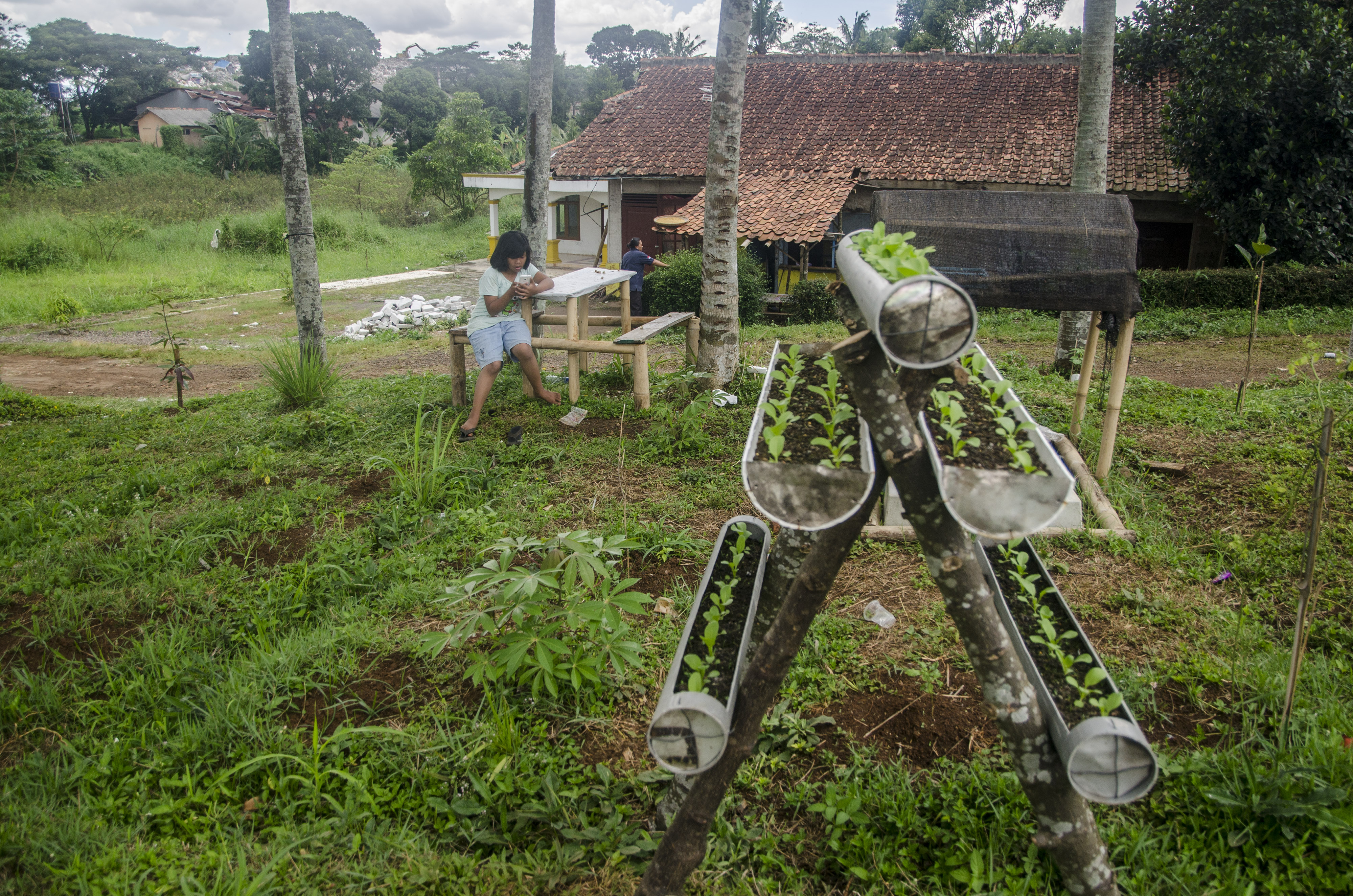 Seorang anak bermain di area lahan dan permukiman kawasan Sirnagalih, Cianjur, Jawa Barat, Senin (28/11).