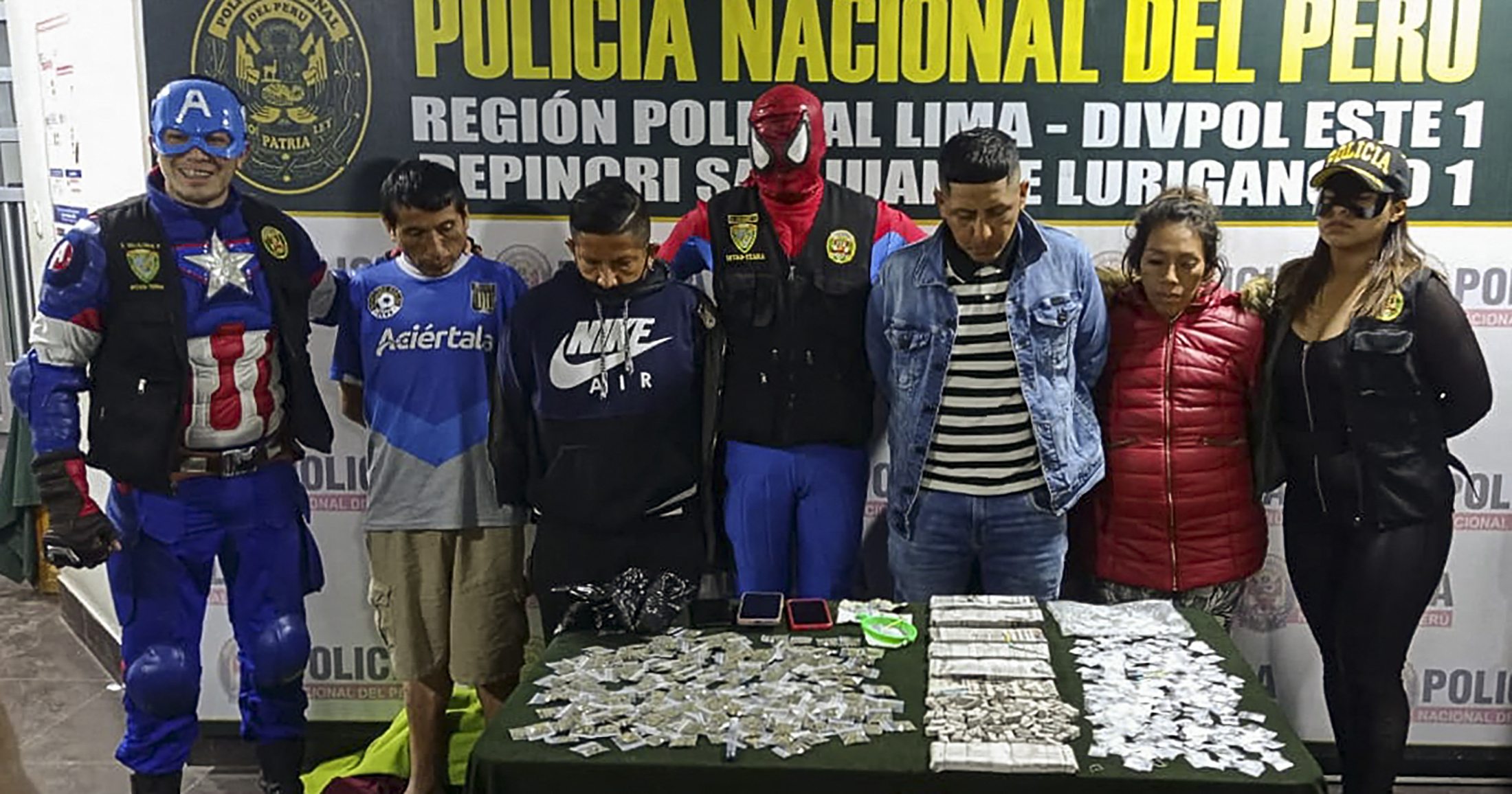 Personel polisi yang mengenakan kostum superhero Avengers saat rilis tersangka dan barang bukti narkoba di Lima, Peru.