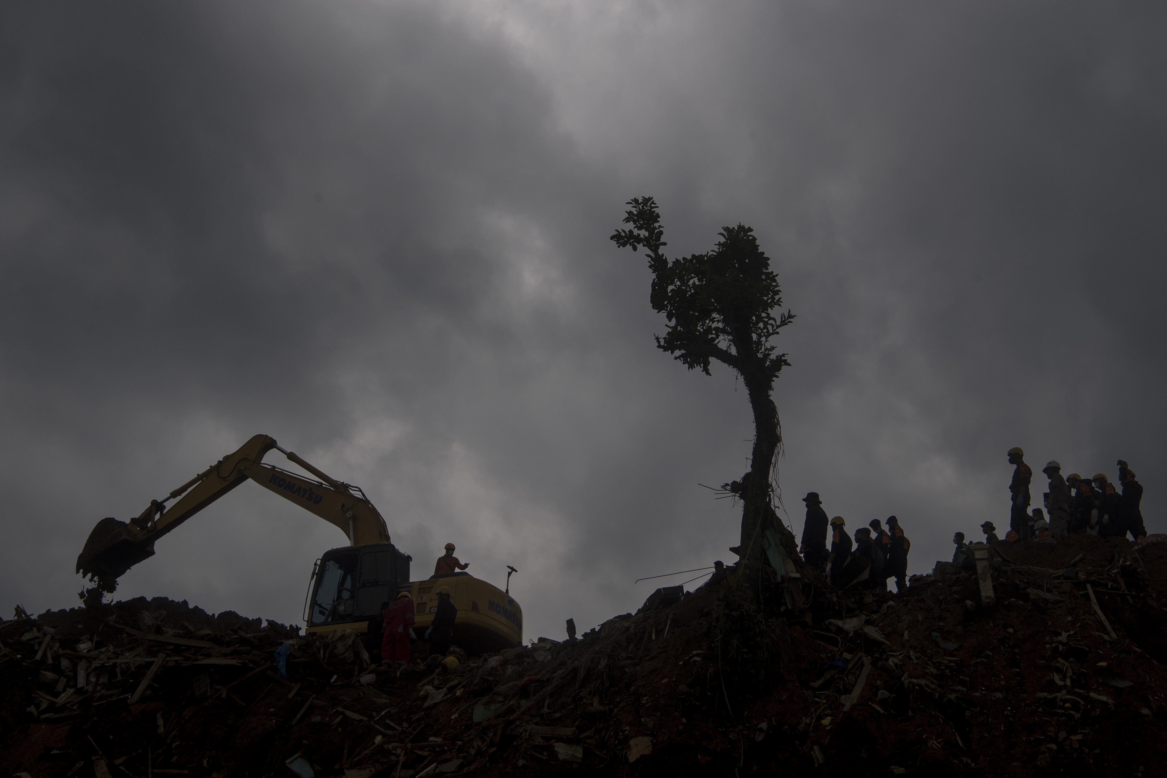 Tim SAR gabungan mencari korban yang tertimbun longsor akibat gempa menggunakan alat berat di Kampung Cijedil, Cugenang, Kabupaten Cianjur.