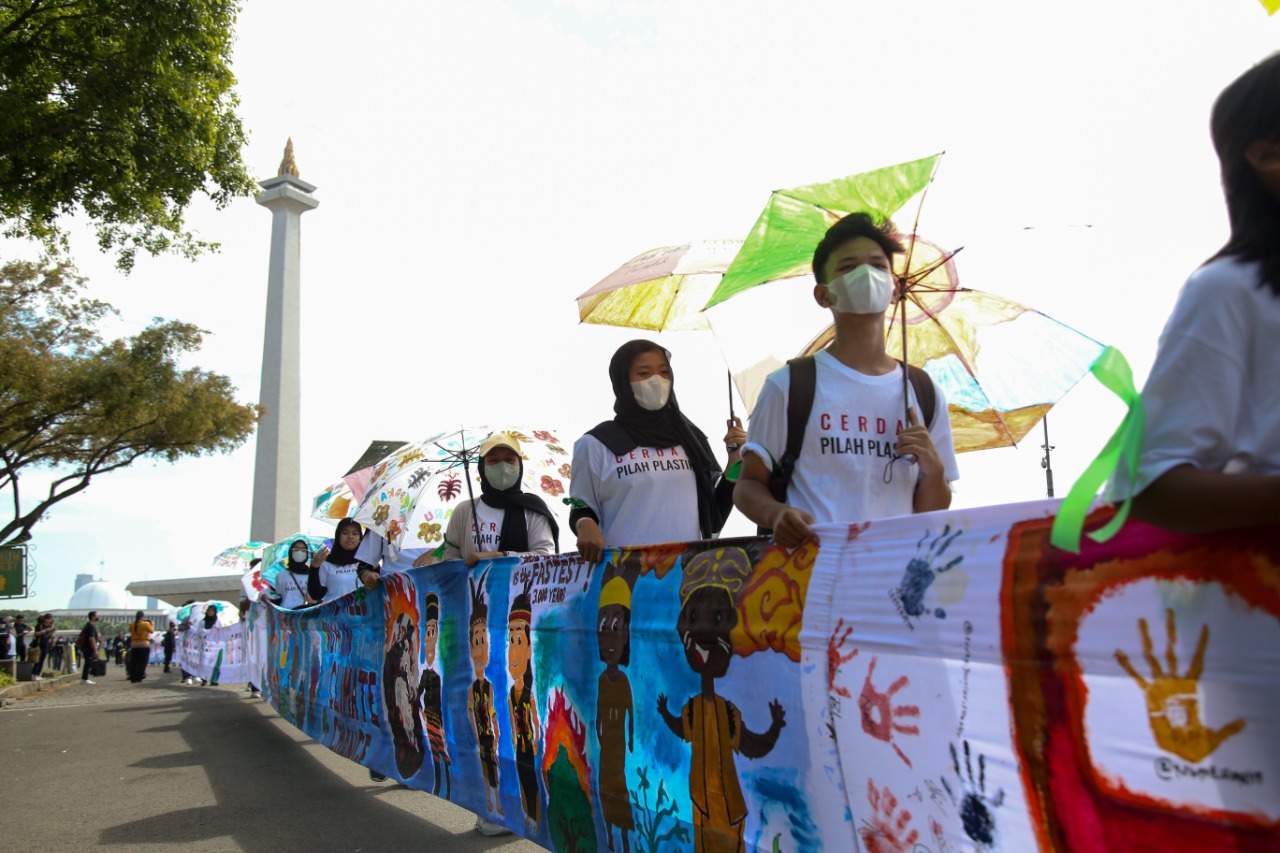 Campaigner Save The Children Indonesia membentangkan spanduk berisi pesan anak-anak dari 4 benua mengenai krisis iklim
