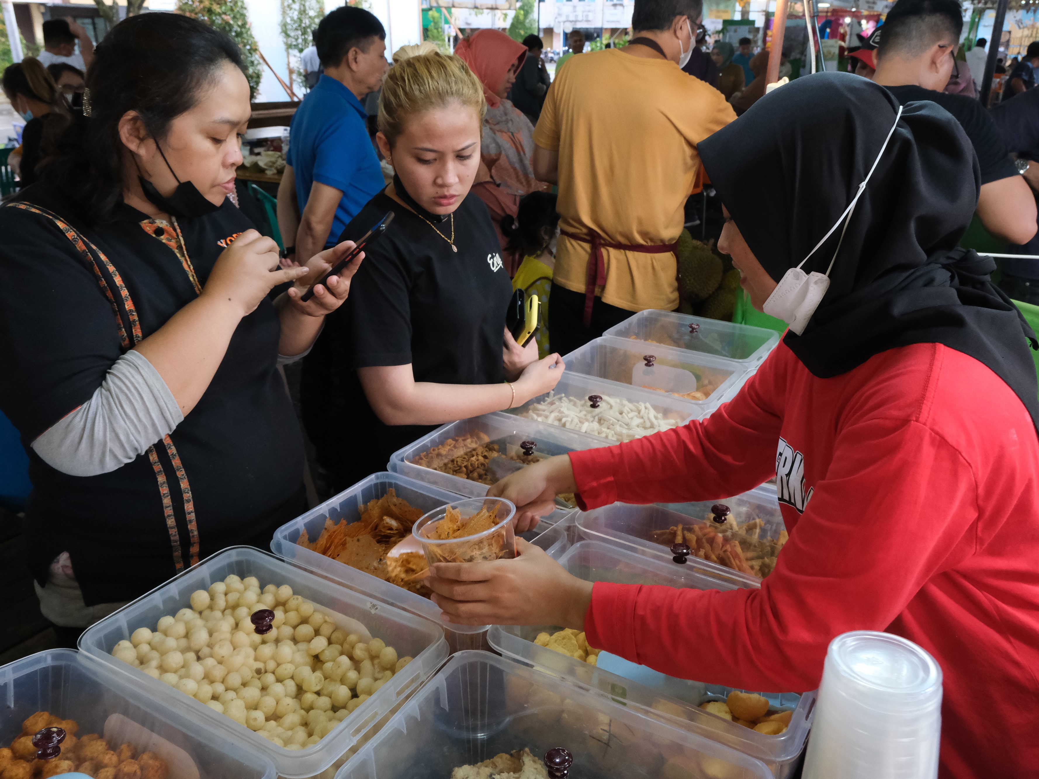 Dua pengunjung membeli camilan ringan yang dijual di Festival Kuliner di halaman parkir Ayani Mall, Pontianak, Kalimantan Barat.