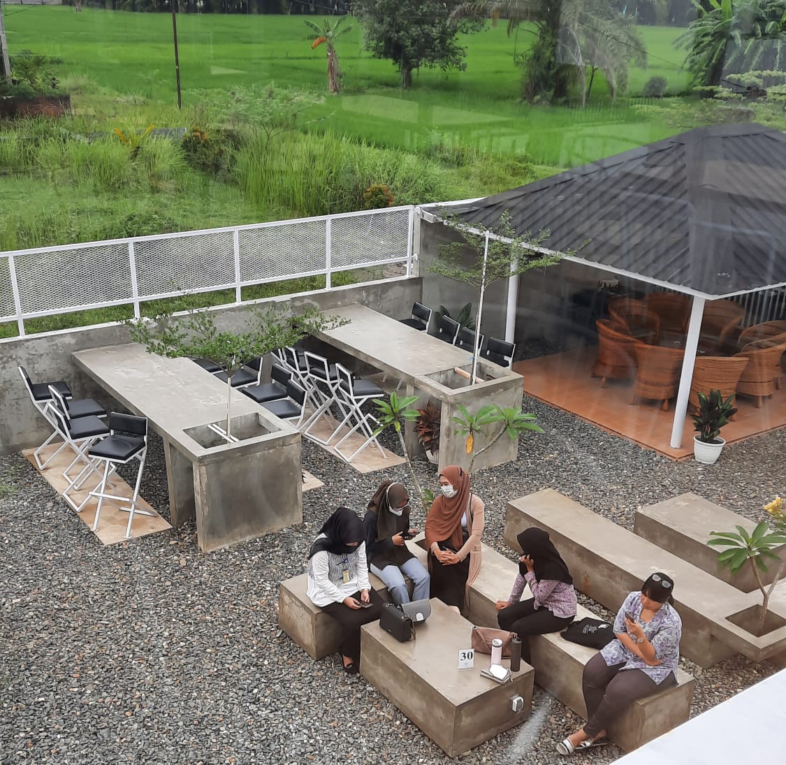 Anak-anak muda berkunjung ke kedai kopi tepi sawah.