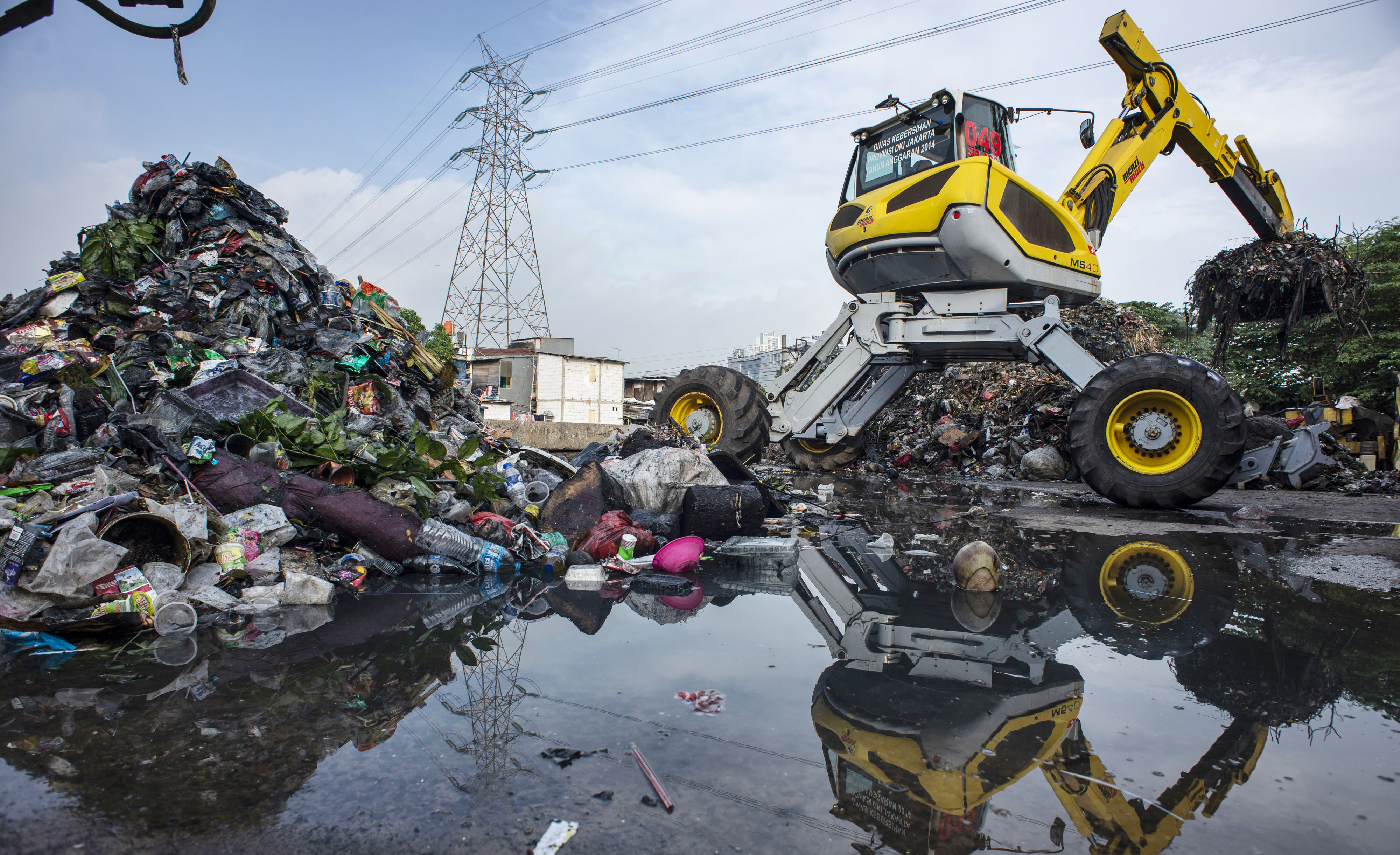 Pekerja dengan alat berat memindahkan sampah di area proyek ITF Sunter, Jakarta.