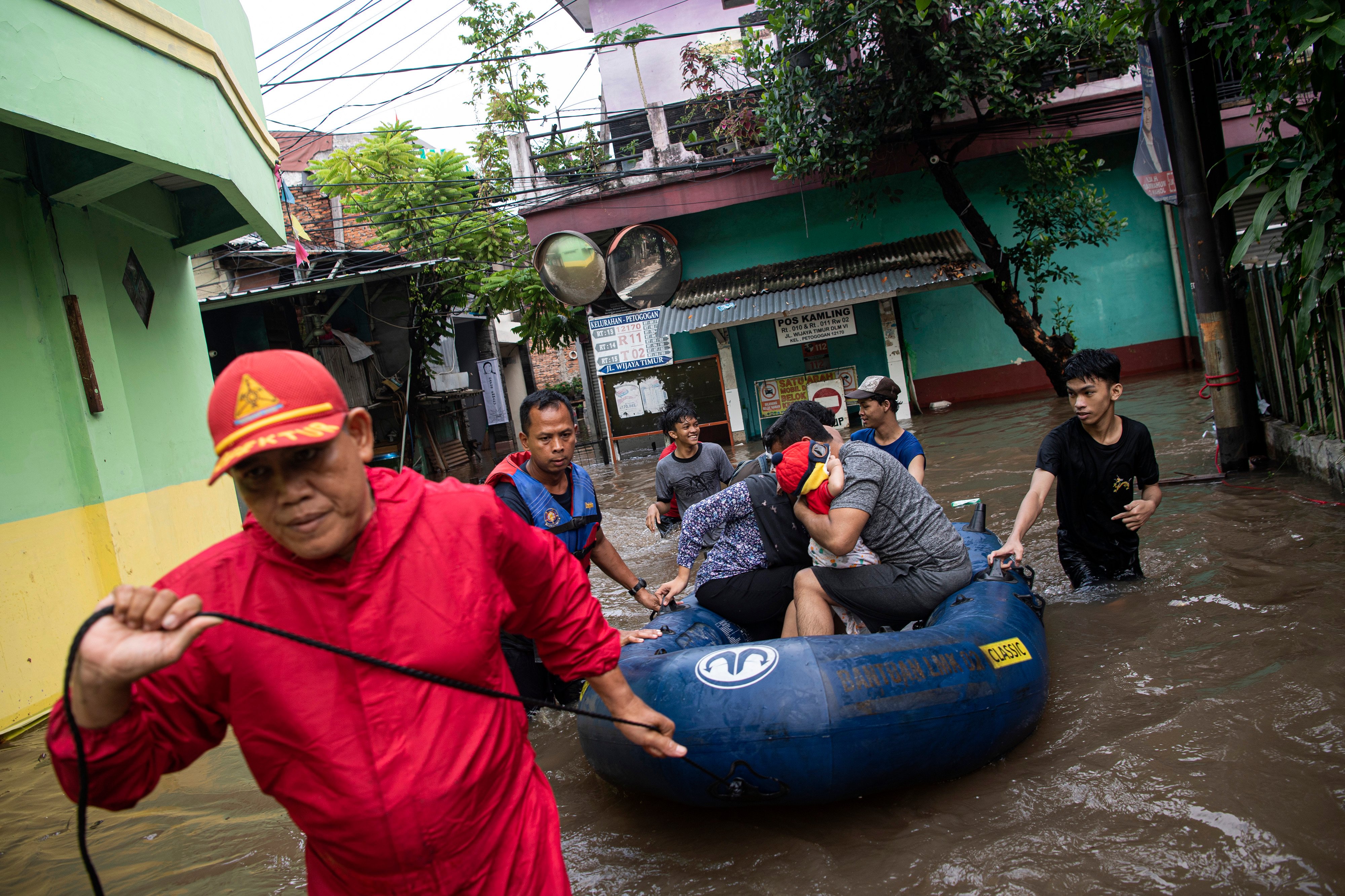 Petugas pemadam kebakaran bersama warga mengevakuasi korban banjir dengan perahu karet di Petogogan, Jakarta Selatan, Sabtu (5/11).