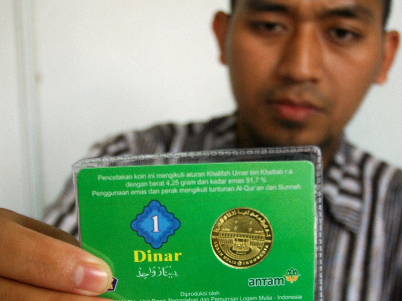 Penjaga stand Dinar, memerlihatkan uang dinar dalam acara Pasar Ukaz di Pusat Dakwah Islam (Pusdai) Bandung, Jawa Barat.