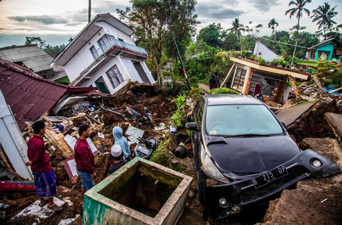 Sejumlah warga berdiri di sekitar rumah yang terdampak gempa di Cianjur, Jawa Barat.