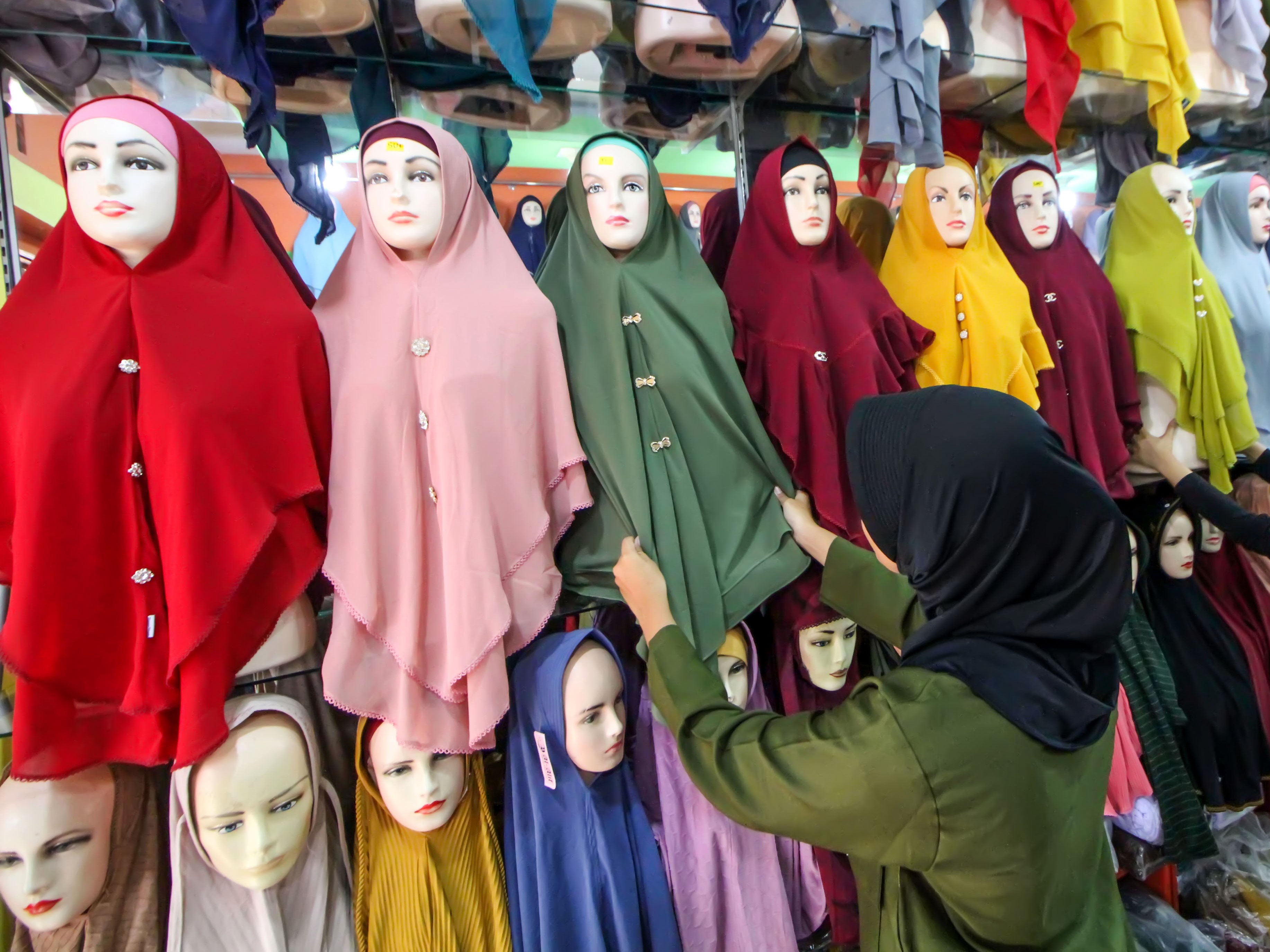 Pedagang busana menata kain jilbab produksi dalam negeri di Lhokseumawe, Aceh, Selasa (19/4/2022).