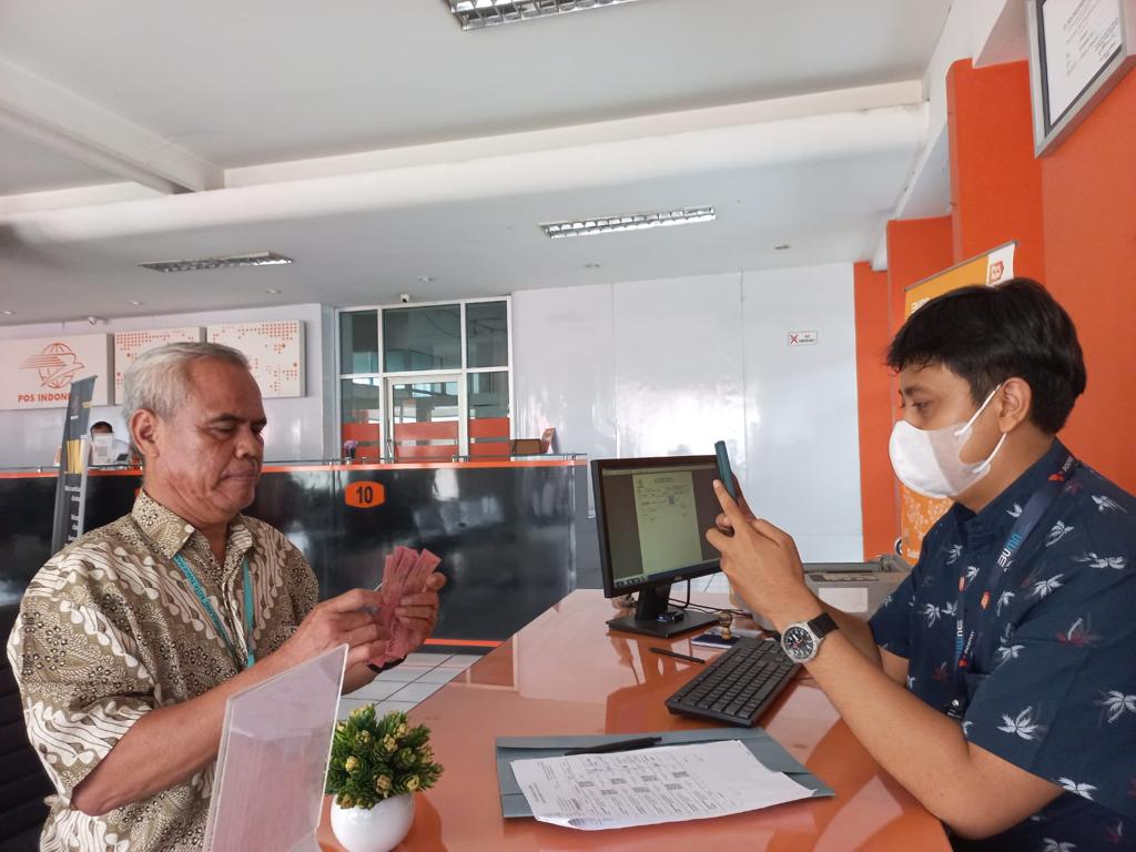 Penerima Bantuan Subsidi Upah (BSU) sedang melakukan verifikasi data di depan pegawai PT Pos Indonesia.