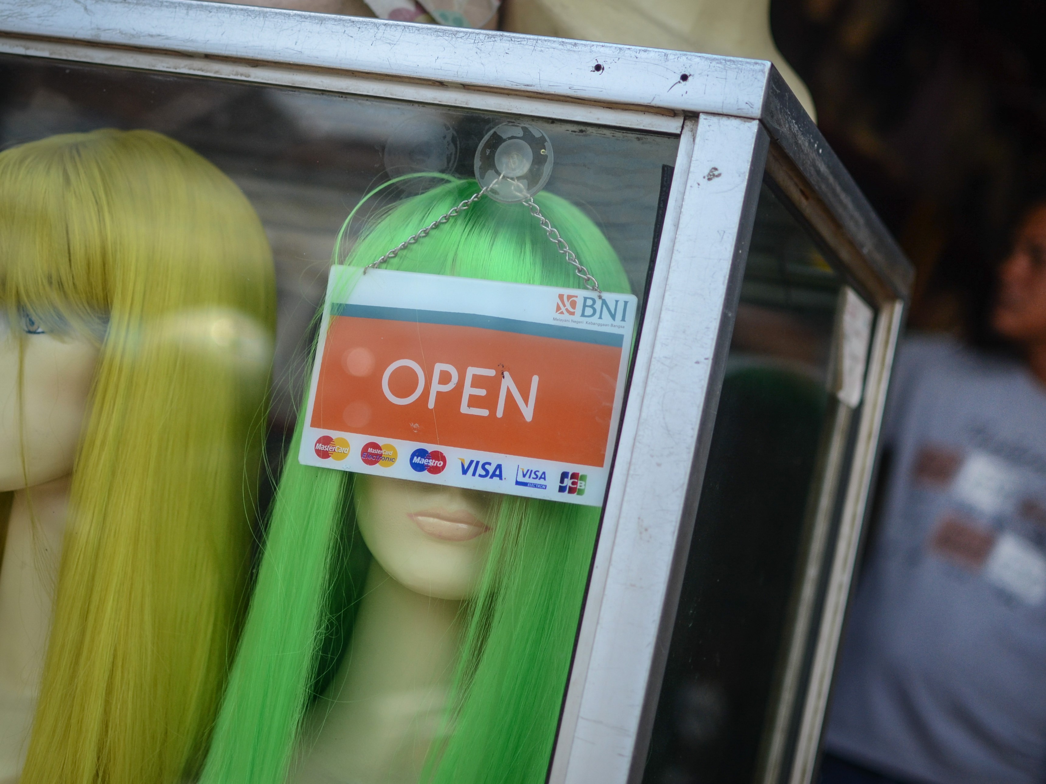 Pedagang merapikan rambut palsu dagangannya di Jalan Suniaraja, Bandung, Jawa Barat.