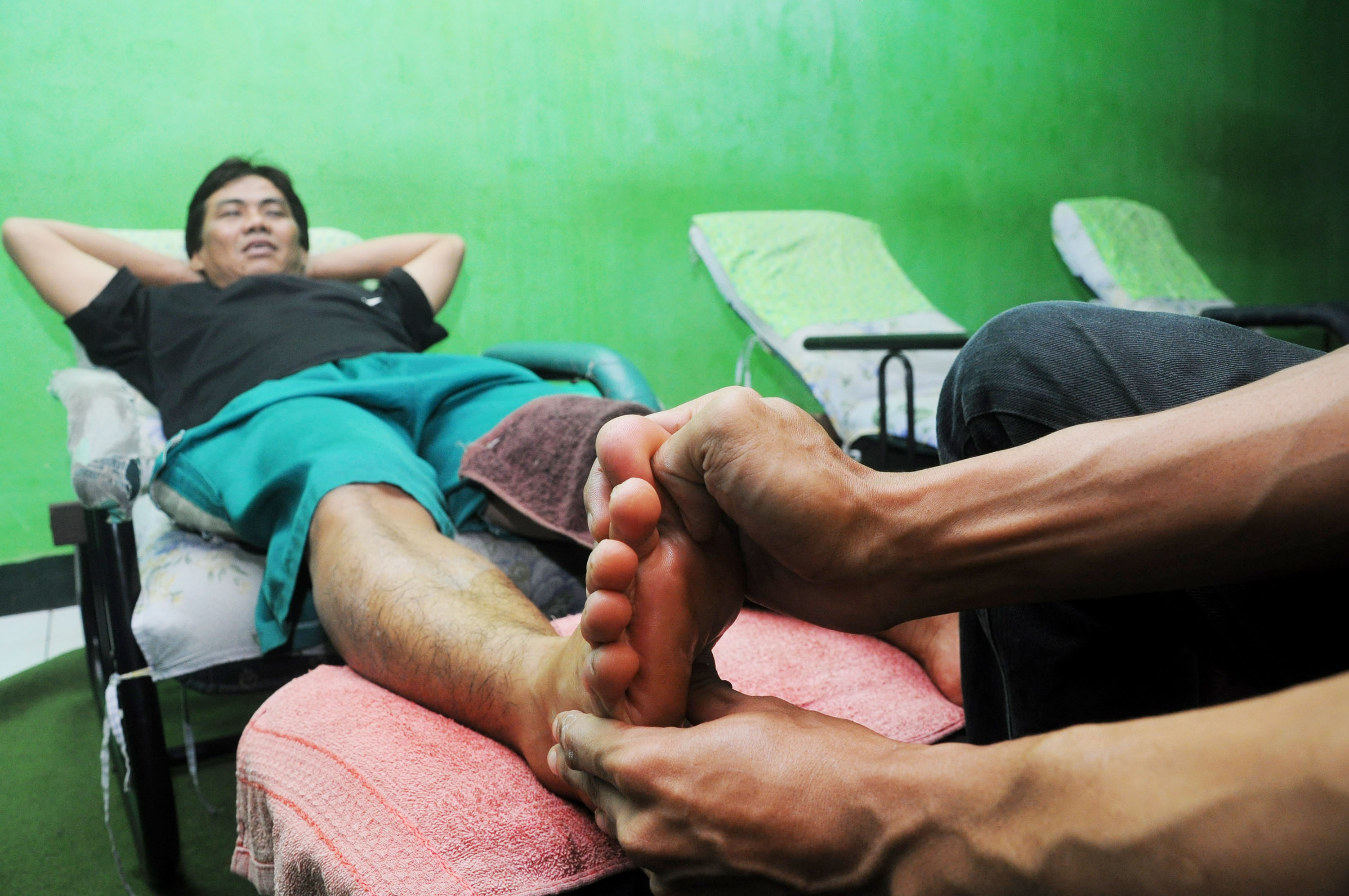 Terapis melakukan pijat refleksi dengan cara memijat di titik-titik bagian kaki tertentu di Ha'ffair Refleksi, Karang Mulia, Tangerang.