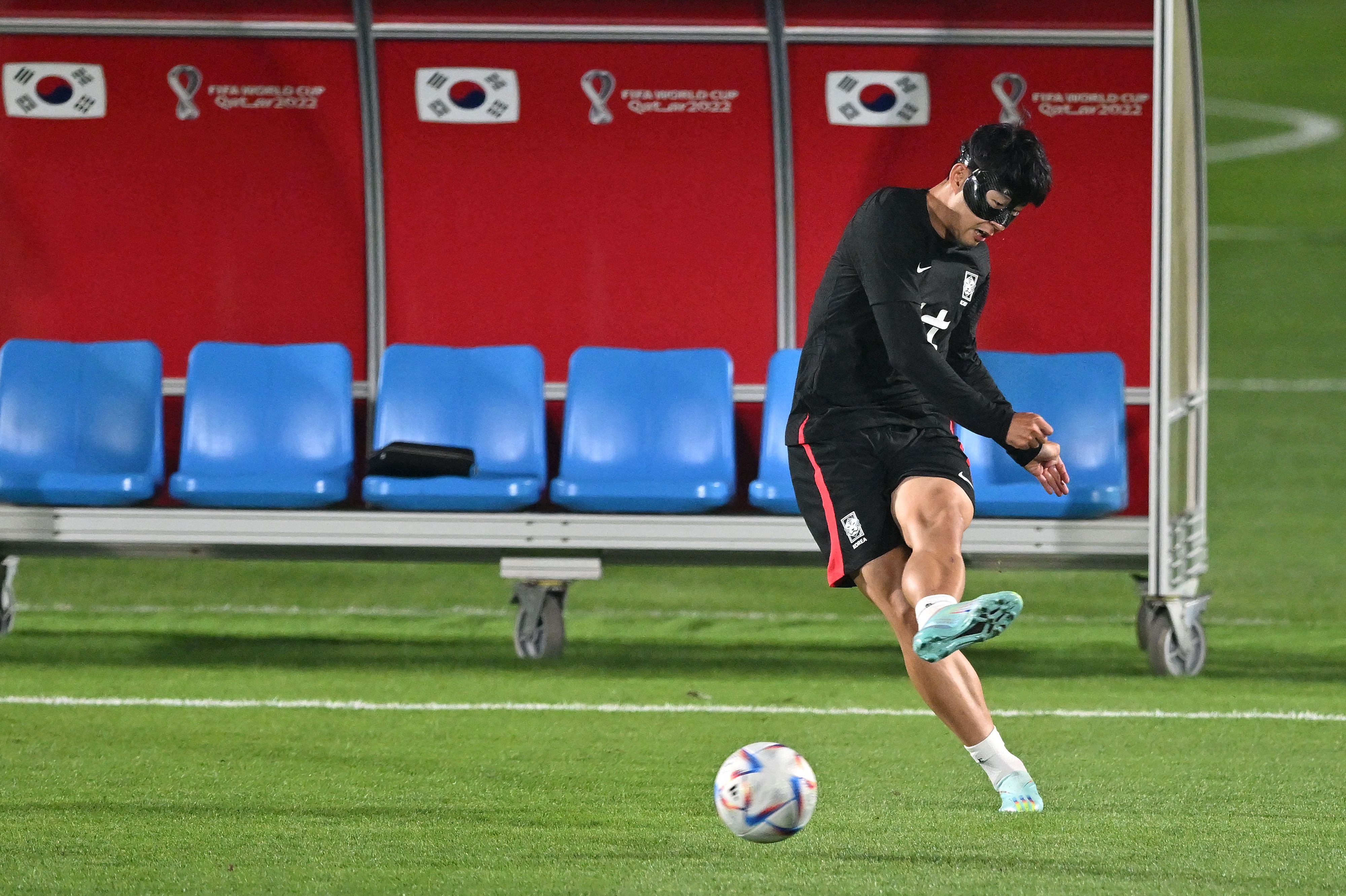 Penyerang Korsel Son Heung Min mengenakan topeng dalam sesi latihan di Doha, Qatar.