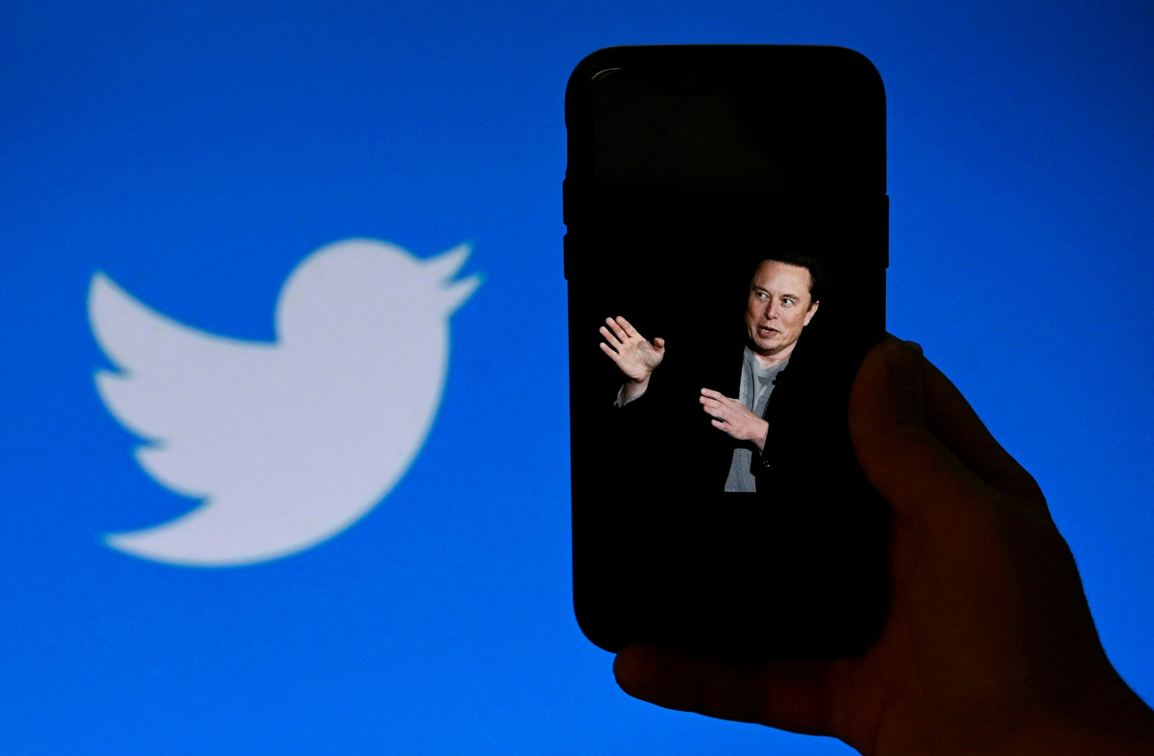 Sebuah ponsel menampilkan foto Elon Musk dengan logo Twitter di latar belakang.