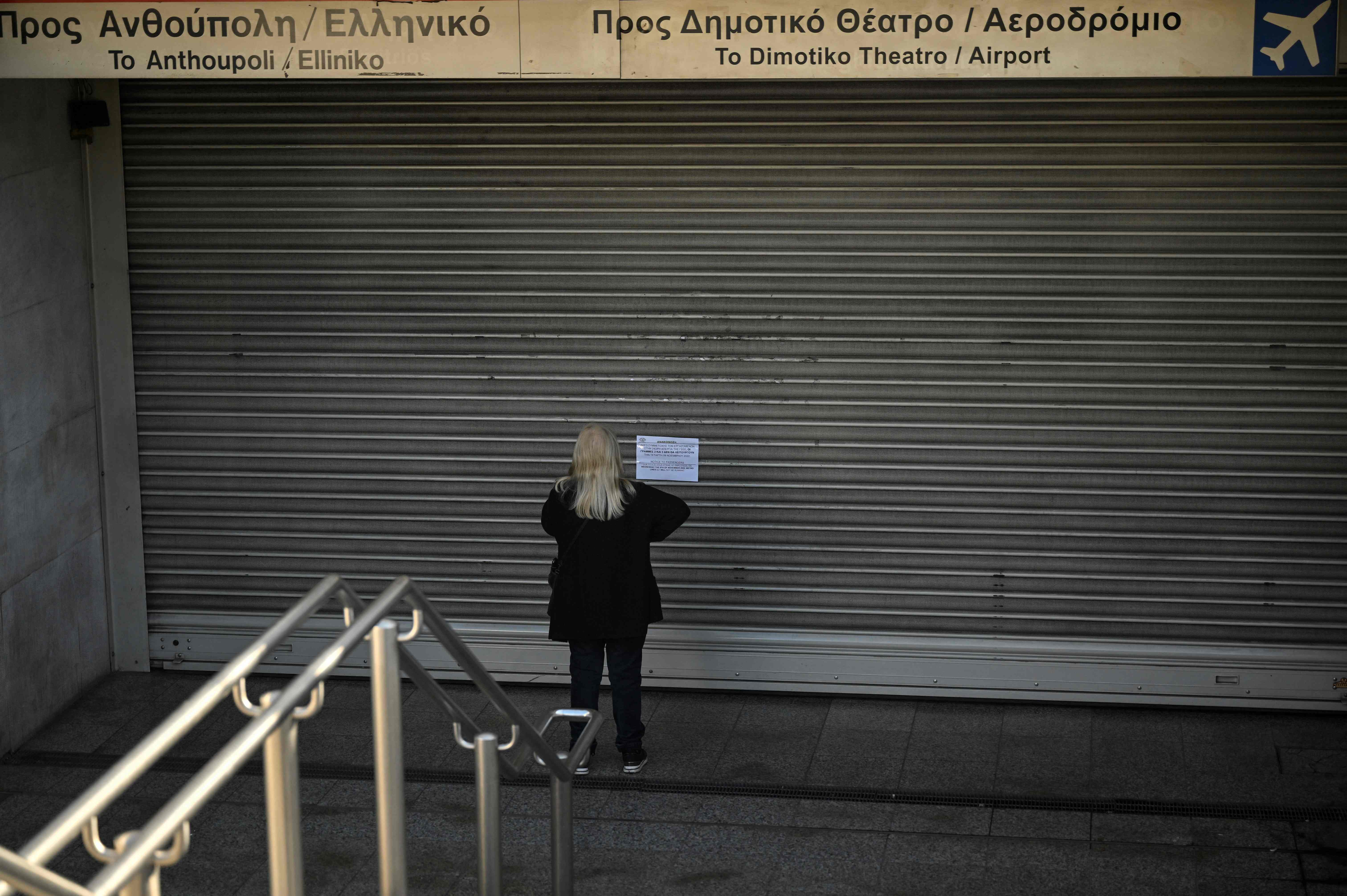 Seorang penumpang membaca pengumuman penutupan stasiun metro karena aksi mogok nasional para pekerja di Yunani, Rabu (9/11).