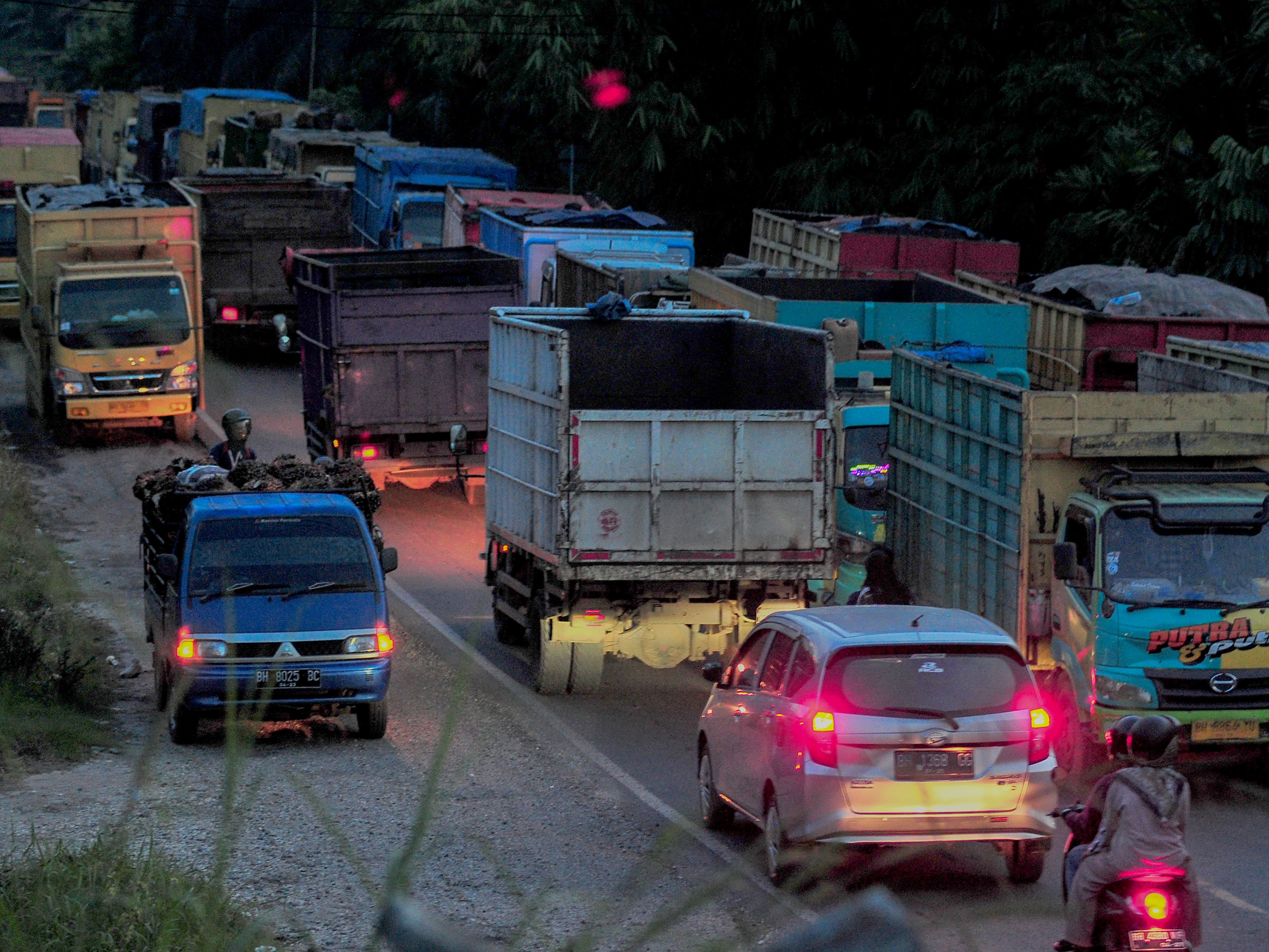 Sejumlah truk angkutan batu bara antre di badan jalan sebelum jam operasional di Muara Tembesi, Batanghari, Jambi, Sabtu (12/11/2022).