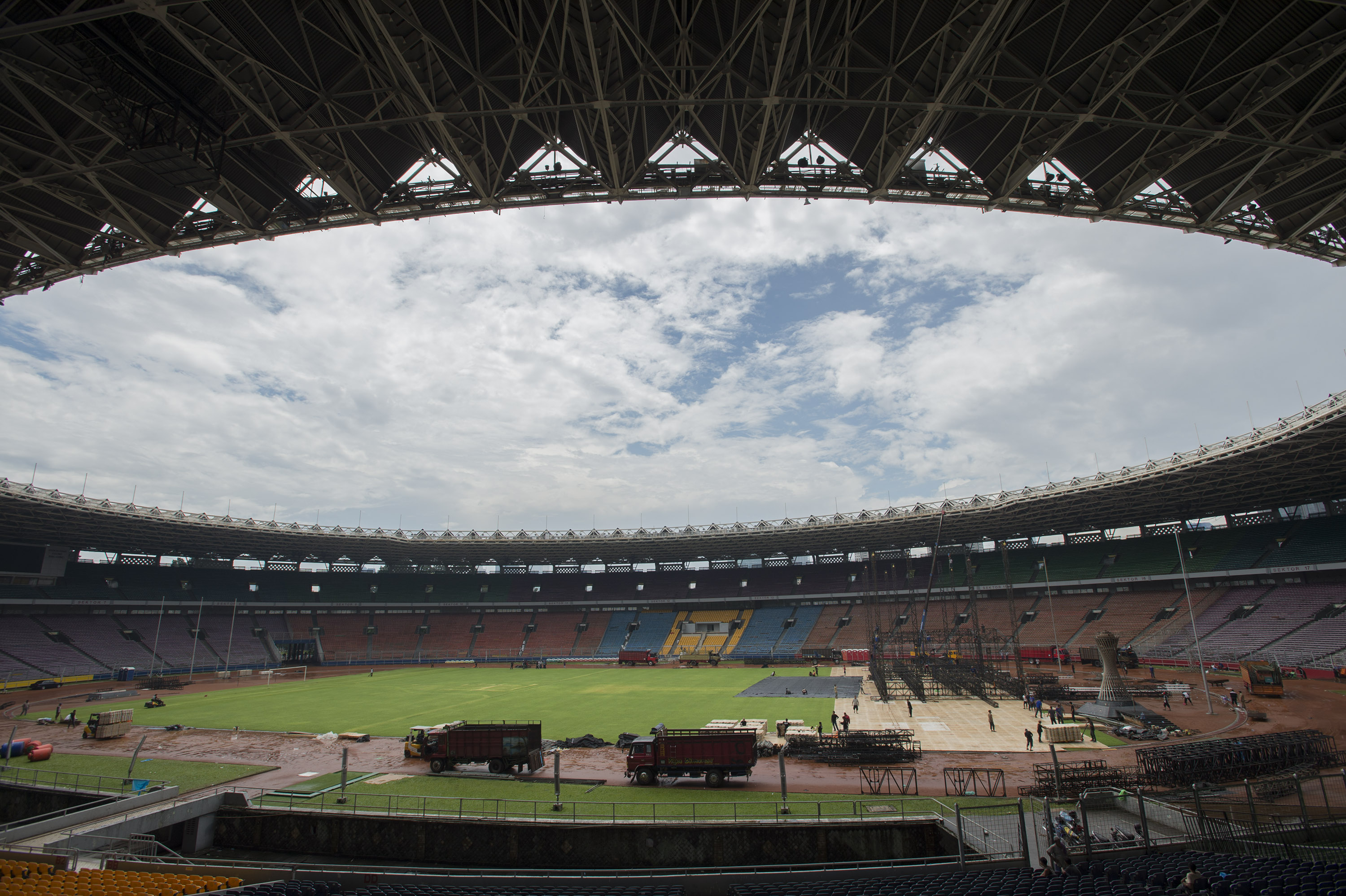 Pekerja membongkar panggung dan penutup rumput (grass cover) usai sebuah konser di Stadion Utama Gelora Bung Karno, Senayan, Jakarta.
