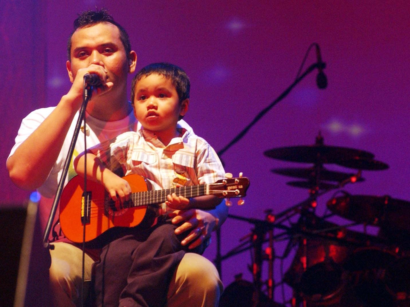 Vokalis kelompok Musik Padi Fadli mengajak sang anak saat menyanyikan lagu.