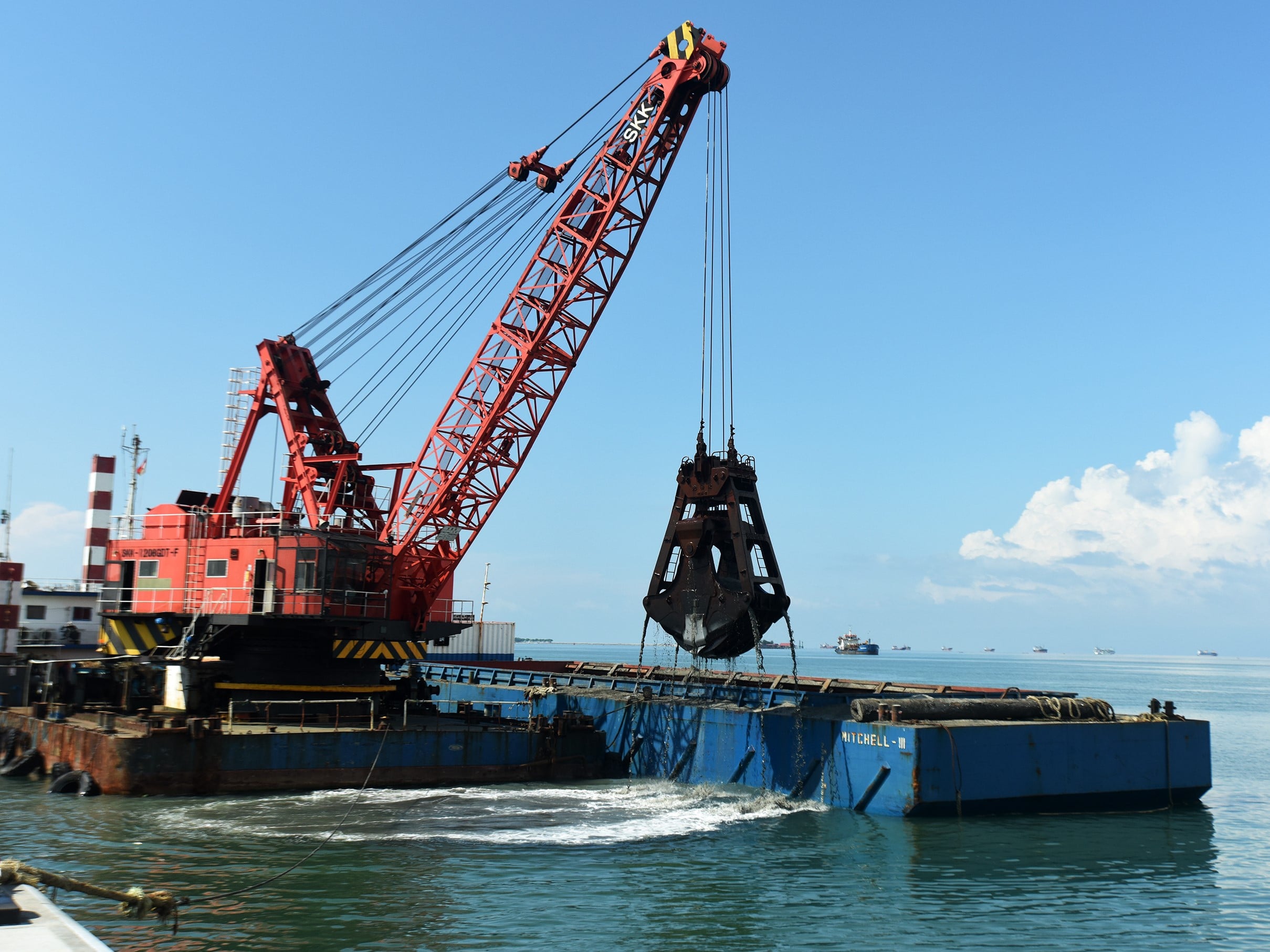 Pekerja mengoperasikan alat berat untuk melakukan pengerukan di dermaga Makassar New Port, Sulawesi Selatan.